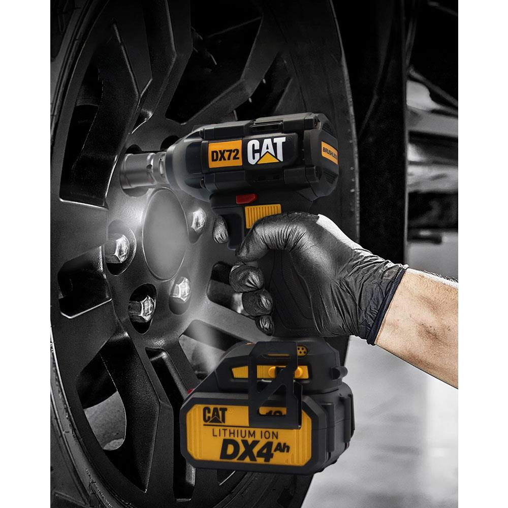 Eldivenli bir el, bir araba tekerleğindeki somunları sıkmak için siyah ve sarı bir Cat DX72 darbeli somun sıkma makinesi kullanıyor.