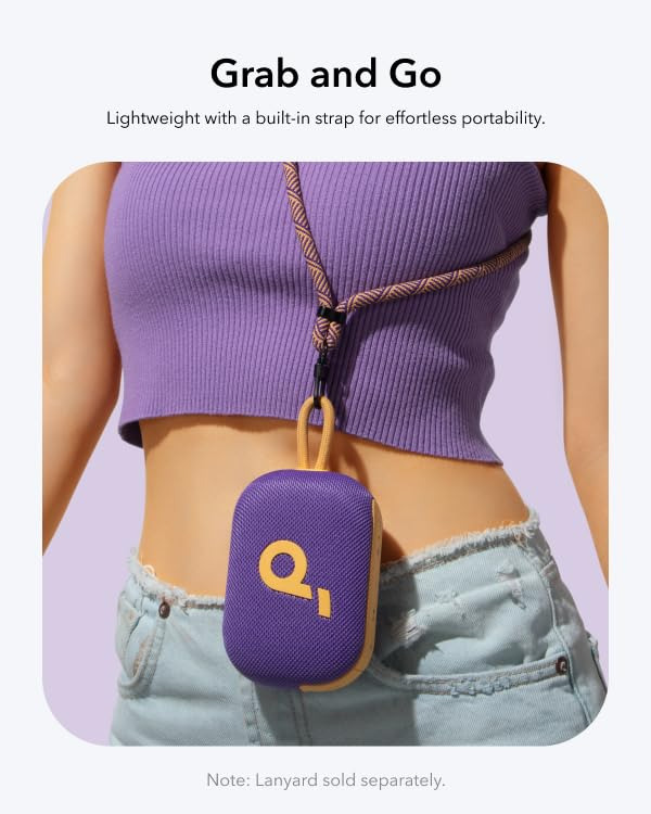 Una persona indossa un top viola, jeans e un altoparlante portatile viola con logo giallo su un cordino.