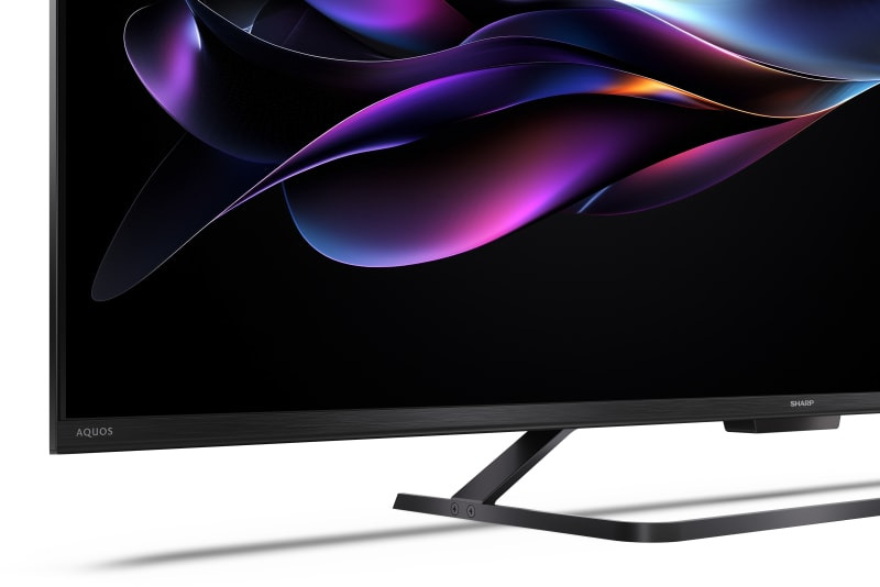 Telewizor z cienką ramką i kolorową grafiką abstrakcyjną na ekranie.