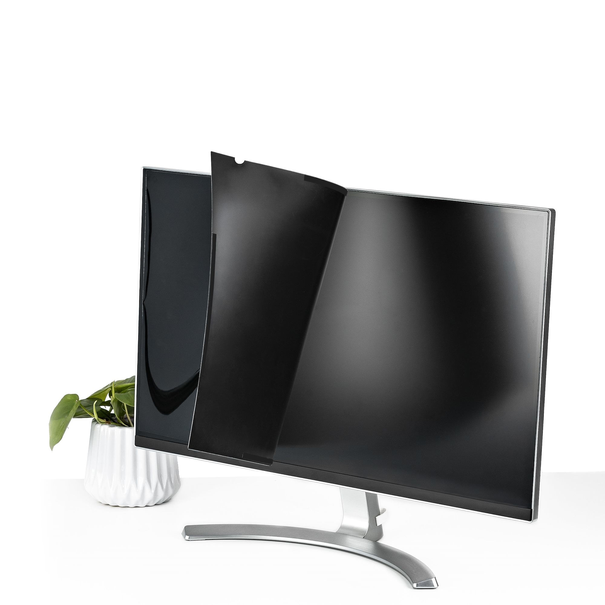 Un monitor claro con soporte plateado tiene una película de privacidad negra parcialmente colocada.