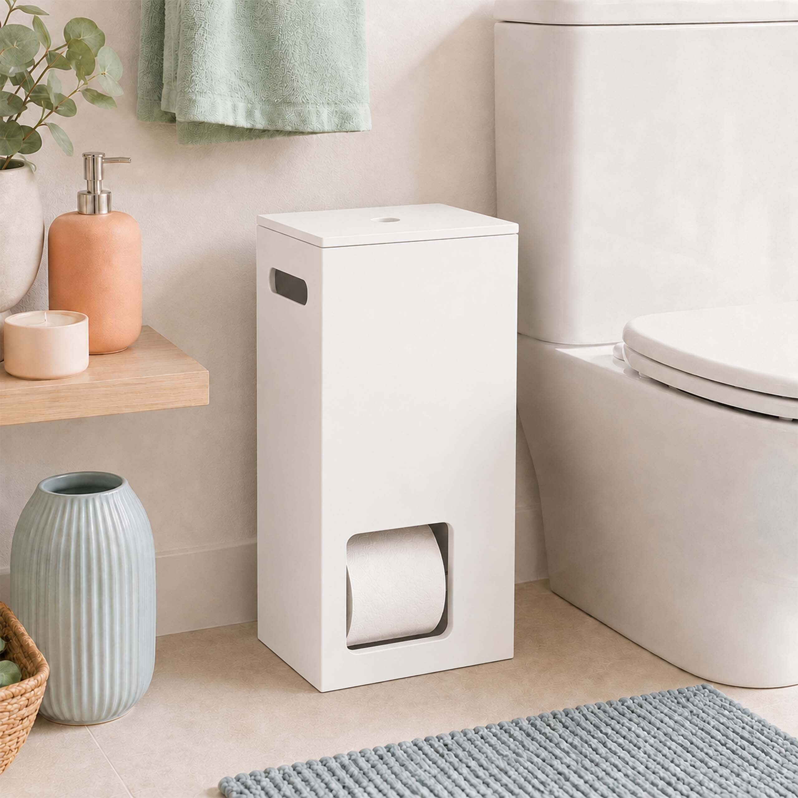Ein weißer Toilettenpapierhalter aus Holz steht neben einer Toilette, daneben eine blaue Vase und ein Seifenspender.