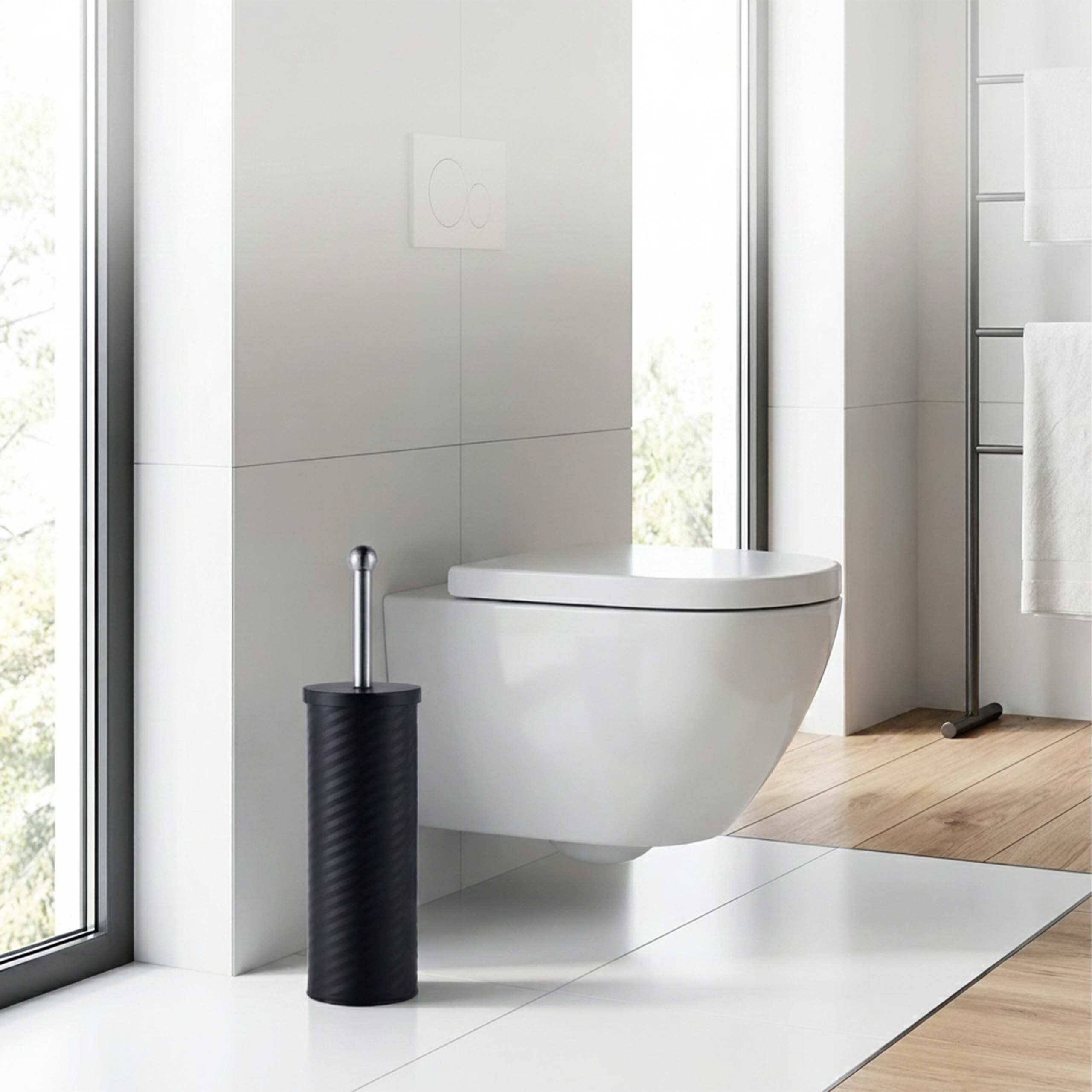 Ein modernes weißes WC mit schwarzem Bürstenhalter im Vordergrund eines hellen Badezimmers.