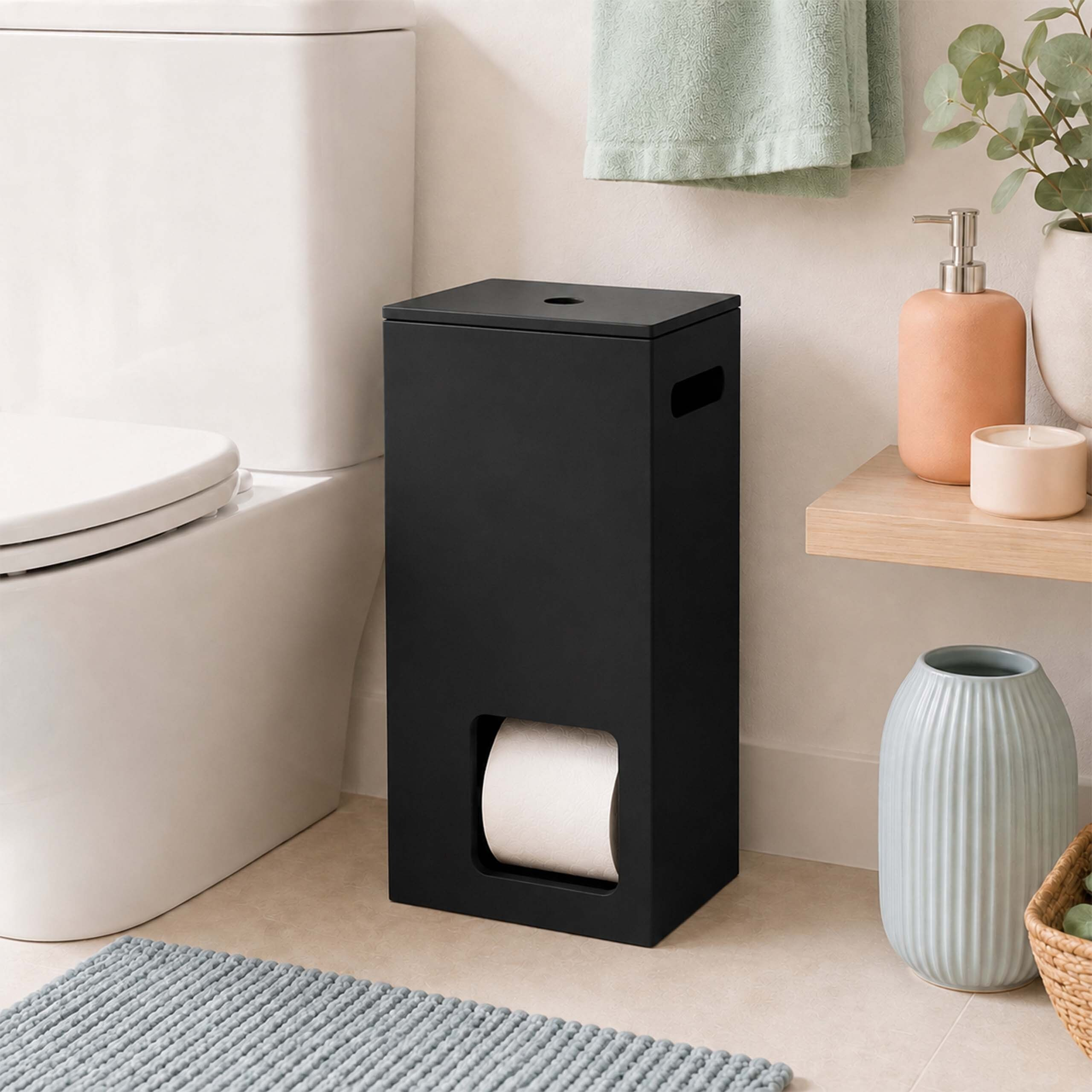 Ein mattschwarzer Toilettenpapierhalter steht in einem Badezimmer neben einer weißen Toilette.