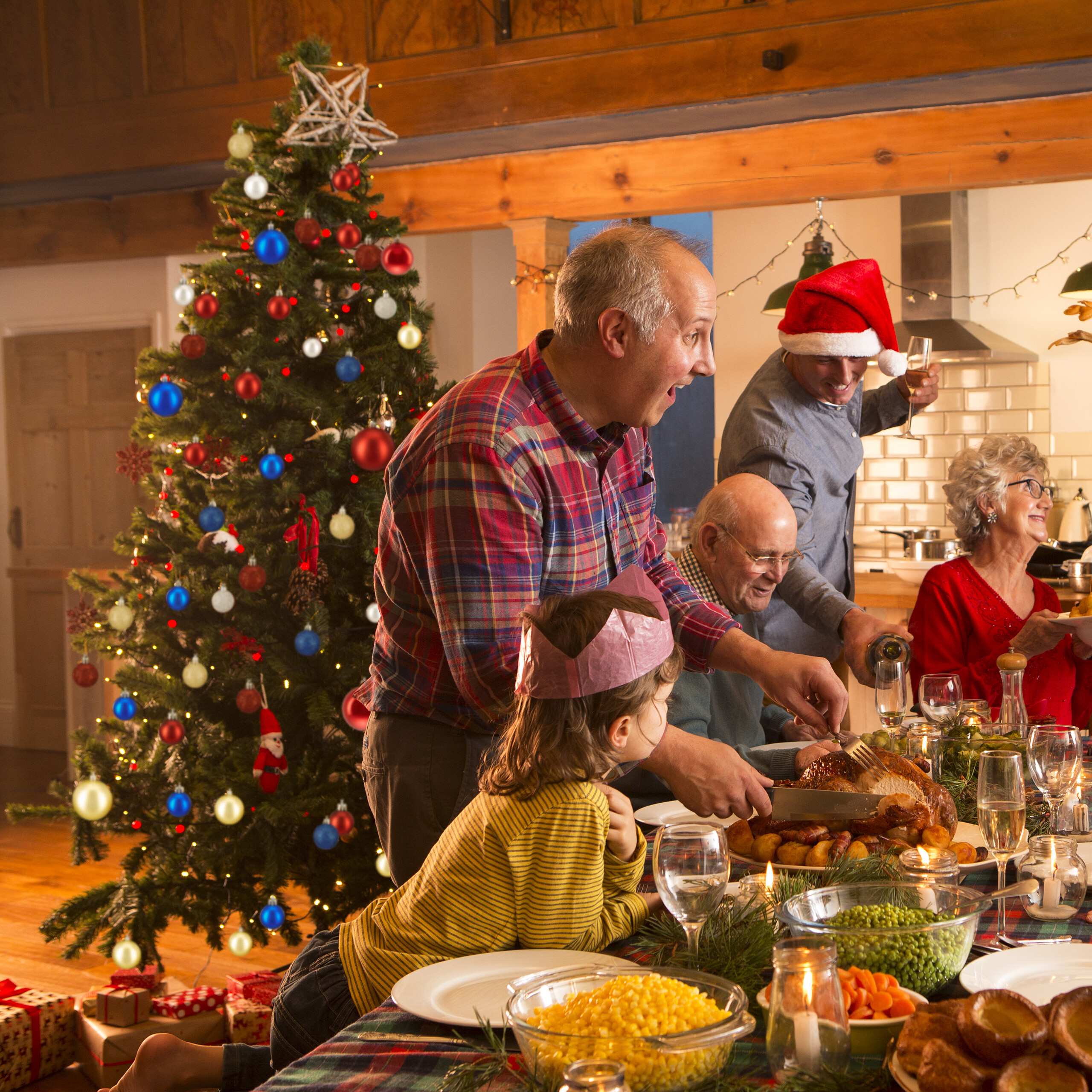 Eine Familie feiert Weihnachten mit festlichem Abendessen, geschmücktem Baum und Truthahn in der Küche.