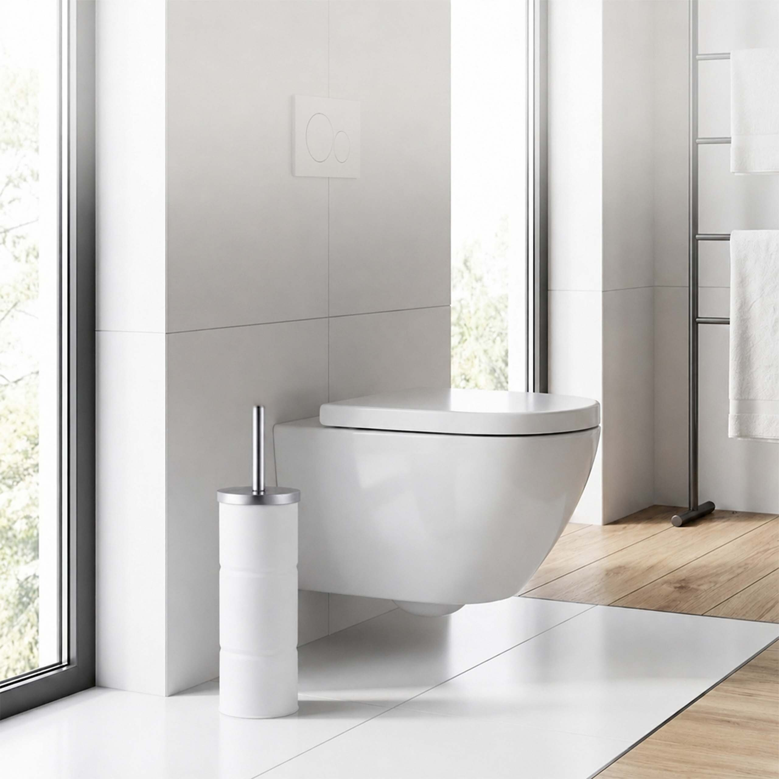 Moderne weiße Toilette und WC-Bürste in hellem Bad mit großen Fenstern und Holzboden.