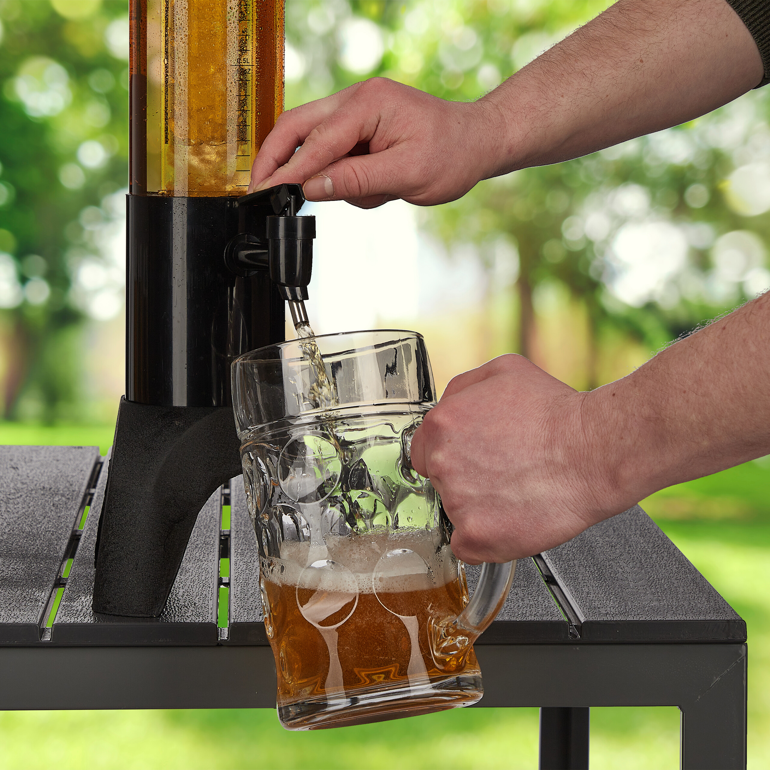 Jemand zapft Bier aus einem Zapfhahn in einen Glaser-Krug auf einem Tisch.