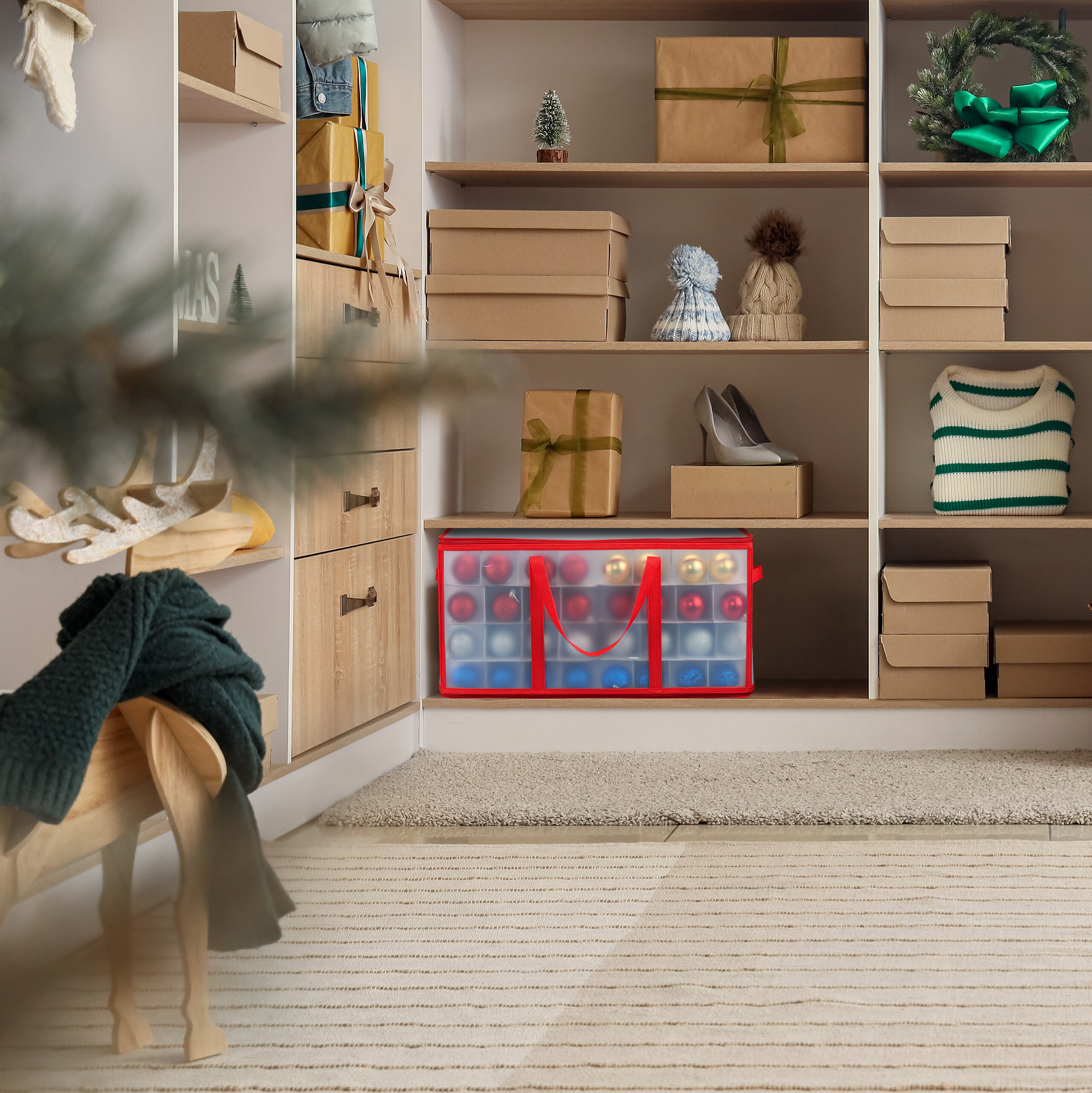 Ein weißer Holzschrank enthält Geschenke, Mützen, Schuhe, Pullover und eine rote Tasche mit Weihnachtskugeln.