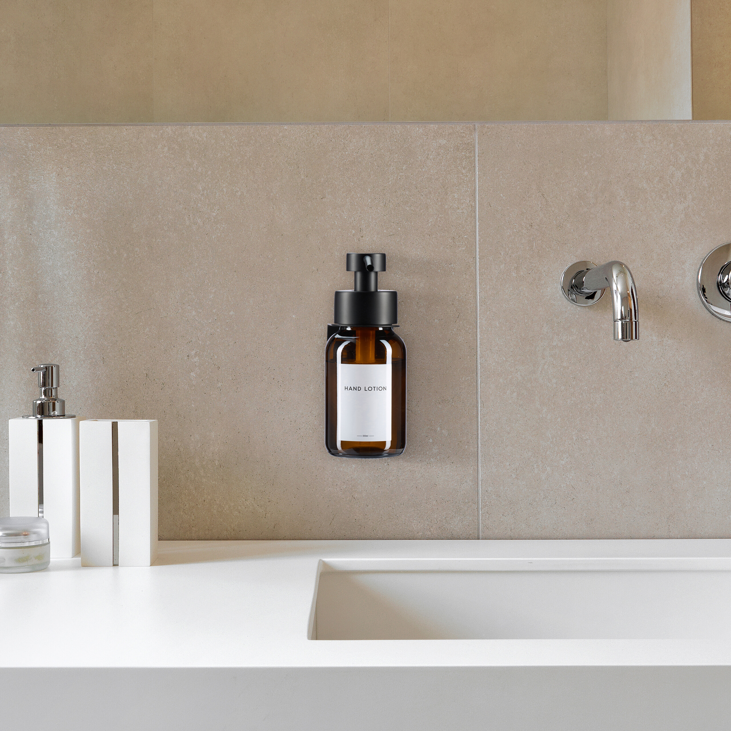 Bernsteinfarbener Handlotion-Spender an einer gefliesten Wand über einem modernen Waschbecken.