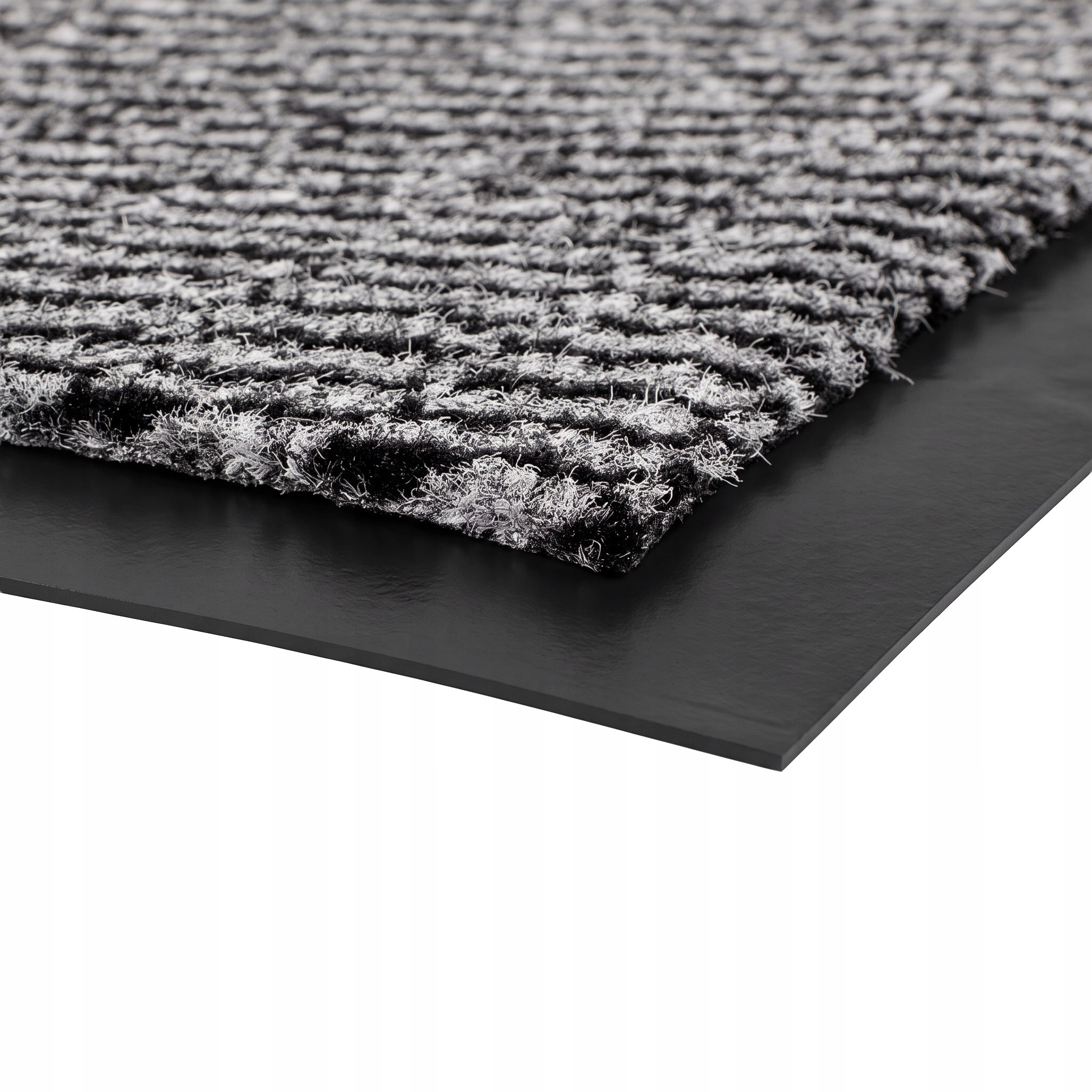 Nahaufnahme einer schwarz-weißen Schmutzfangmatte auf einer glatten schwarzen Unterlage.