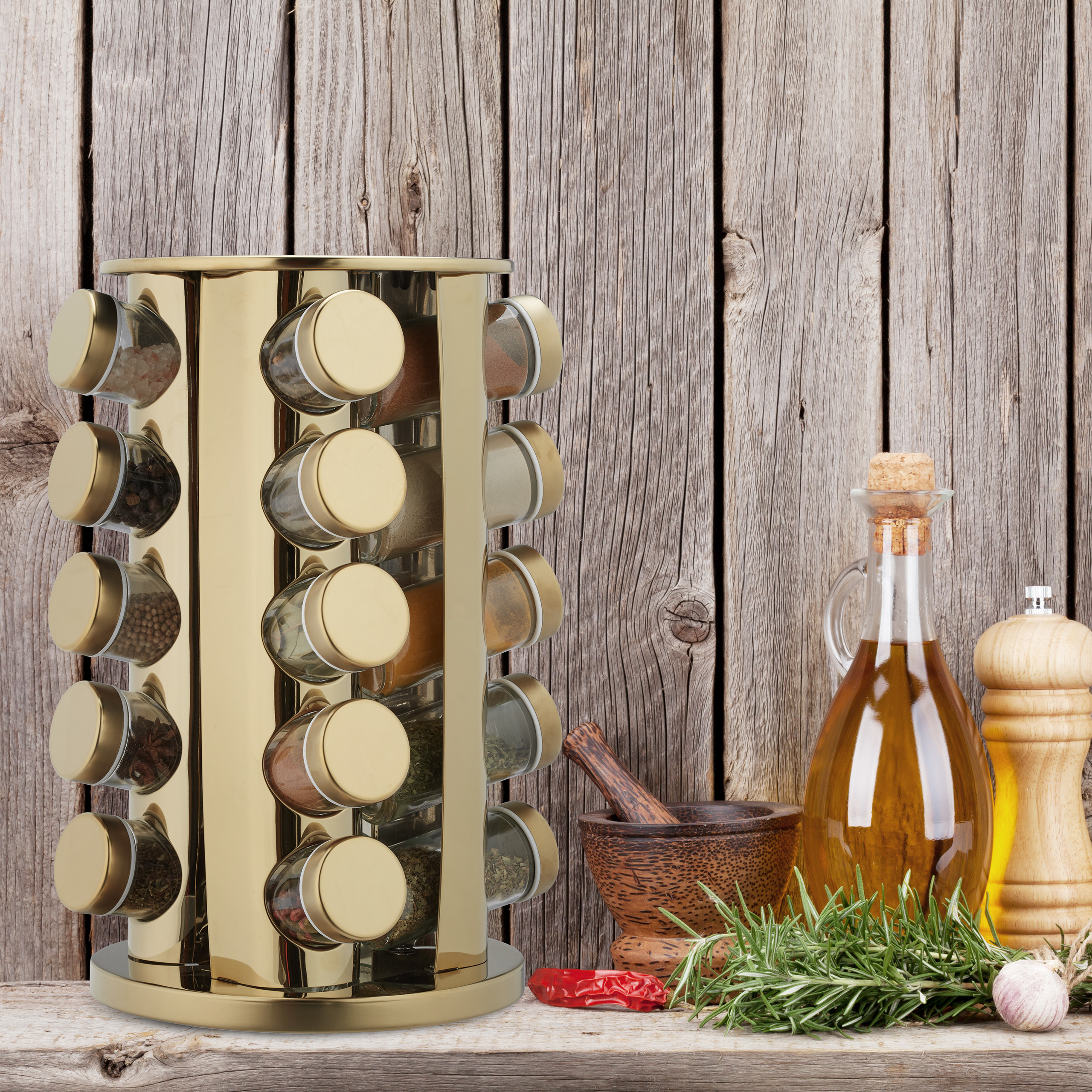 Ein goldener Gewürzregal, Ölflasche, Mörser, Pfeffermühle und Kräuter auf Holz vor Holzwand.
