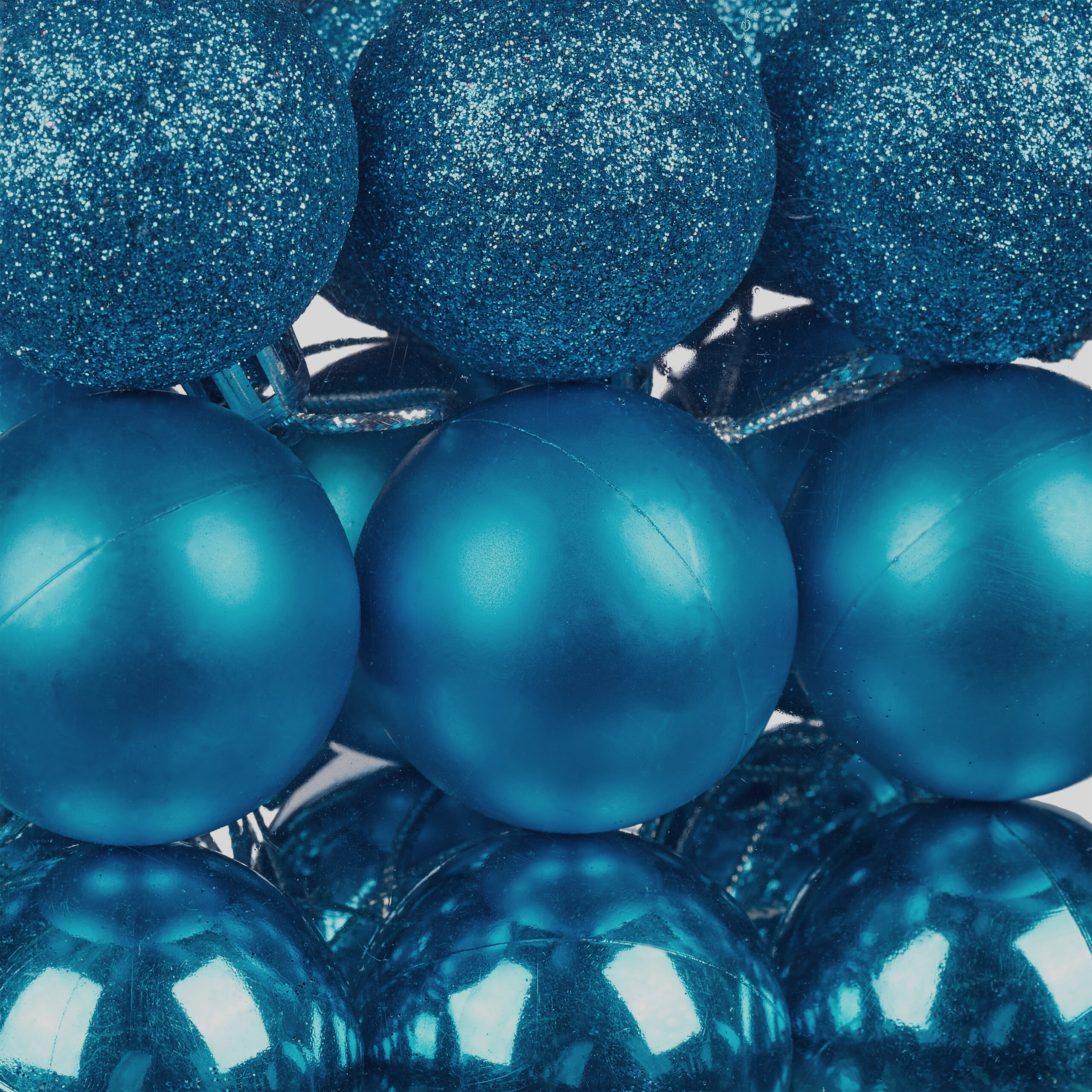 Nahaufnahme blauer Weihnachtskugeln mit glitzernden, matten und glänzenden Kugeln übereinander.