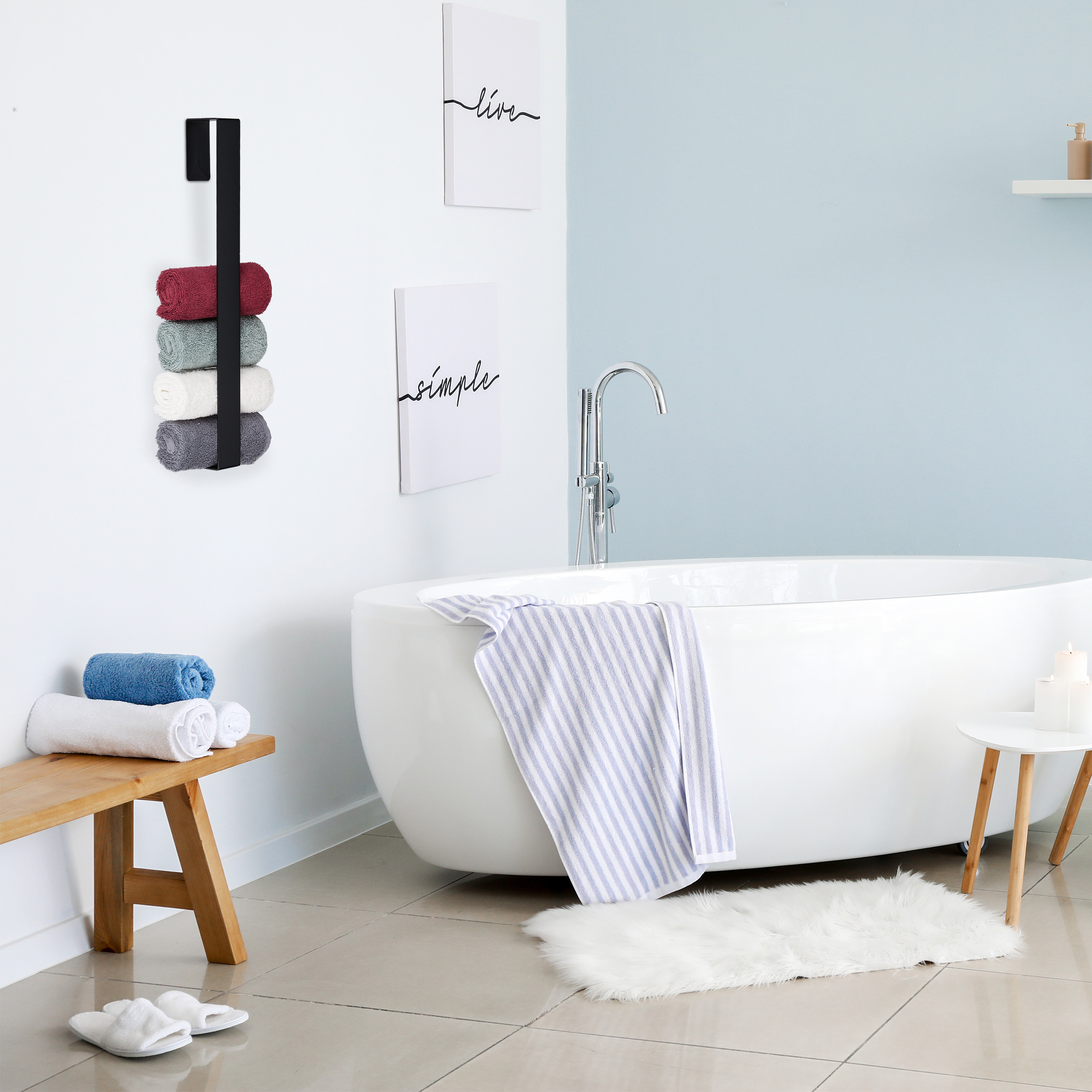 Moderne Badezimmerinneneinrichtung mit weißer Badewanne, Handtuchhalter an der Wand und dekorativen gerahmten Bildern.