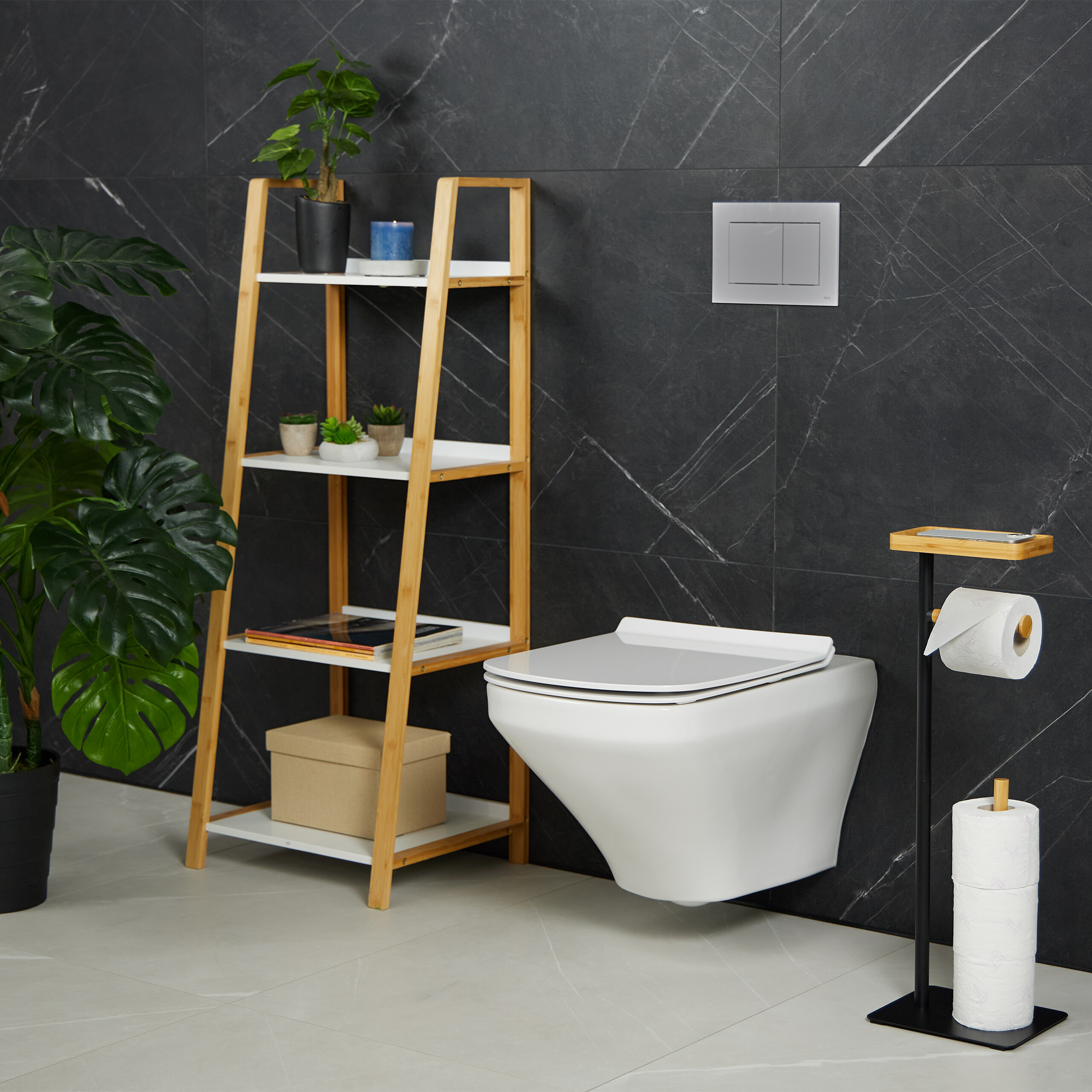 Moderne Toilette mit Bambusregal, Pflanzen und WC-Papierhalter vor dunkler Marmorwand.