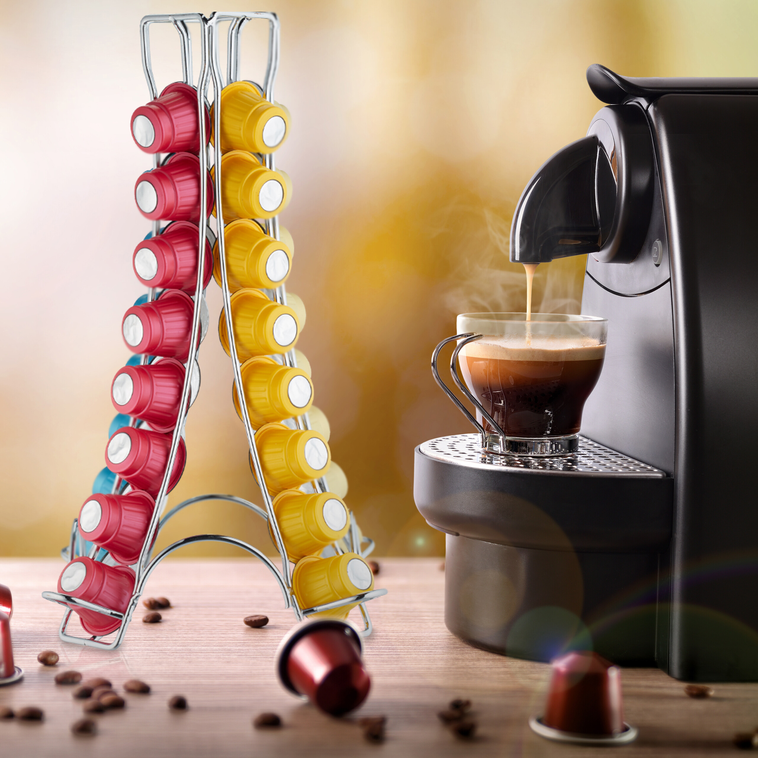 Eine schwarze Kaffeemaschine füllt eine Tasse Kaffee. Neben ihr steht ein Metallständer mit roten und gelben Kaffeekapseln.