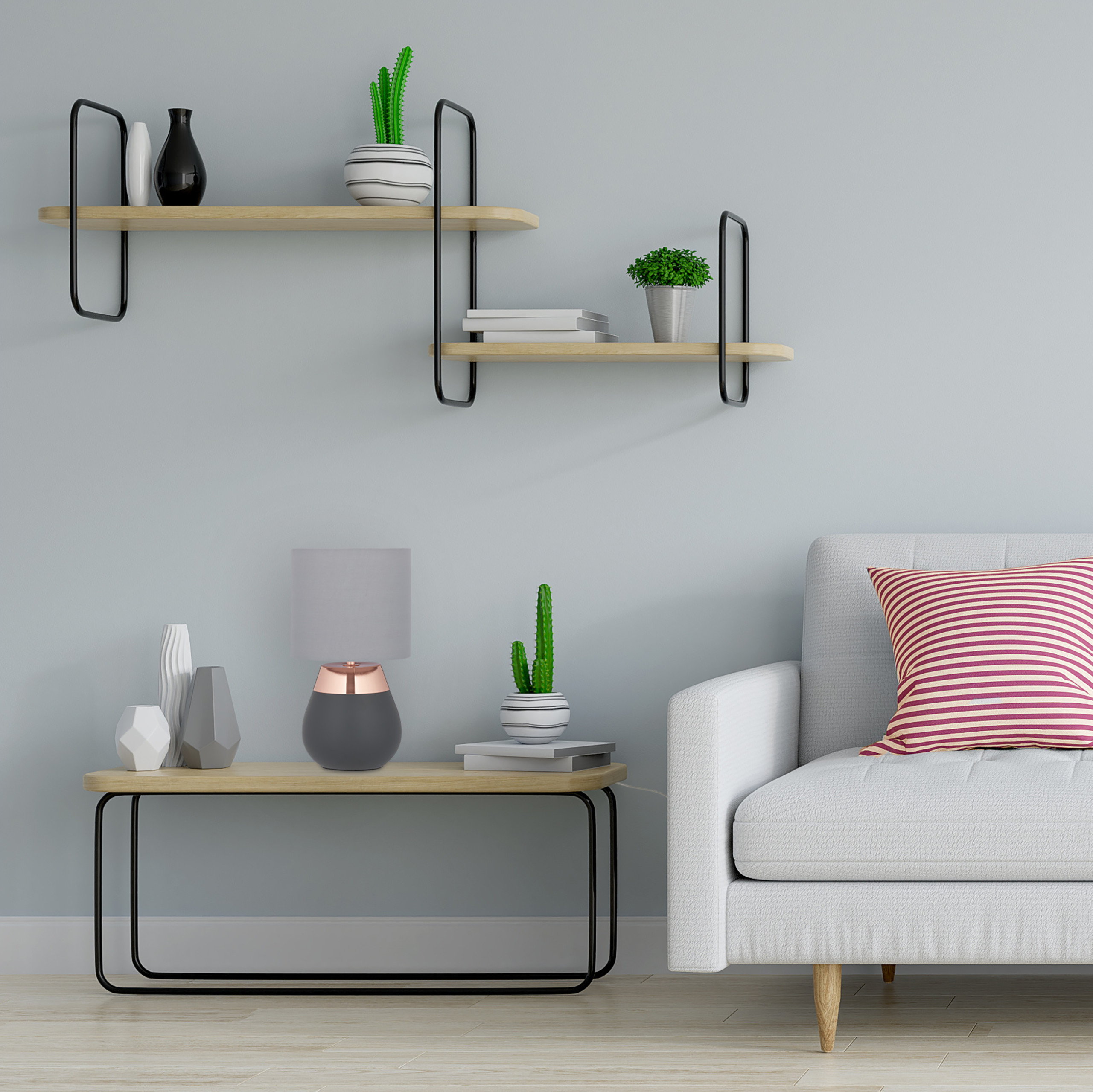 Ein graues Sofa mit rot-weißer Kissen und ein Holztisch mit Lampe und Kaktus. An der Wand hängen Regale mit Deko.