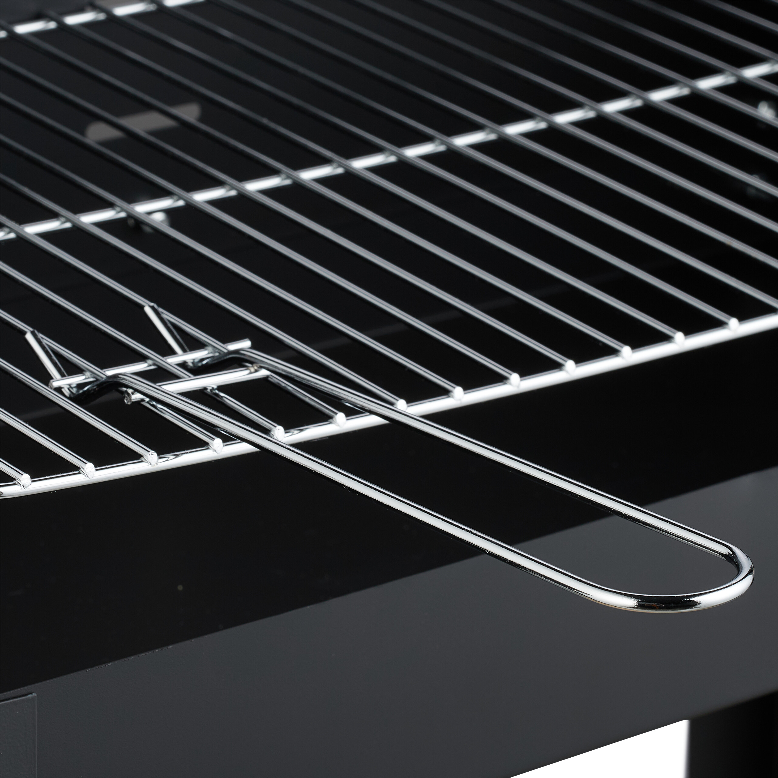 Nahaufnahme eines glänzenden Chrom-Grillrosts über einem schwarzen Grill.