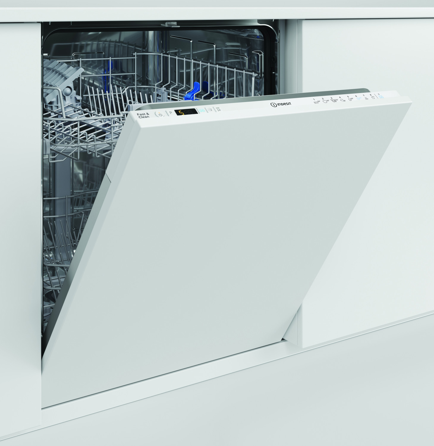 Una lavastoviglie Indesit bianca è a metà aperta in cucina, rivelando i cestelli interni vuoti.