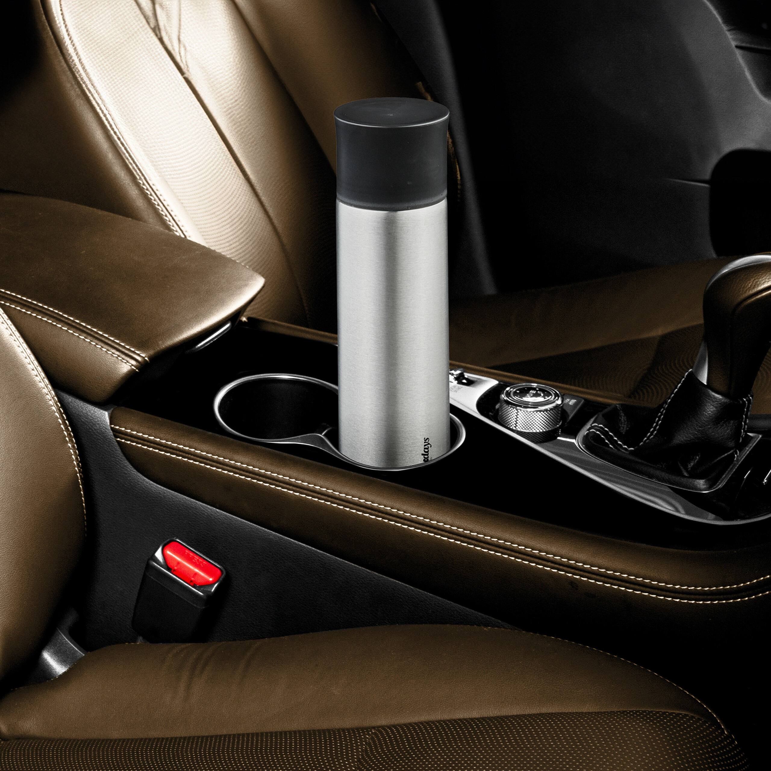 Eine edle Thermoskanne steht sicher im Getränkehalter einer luxuriösen braunen Auto-Mittelkonsole.