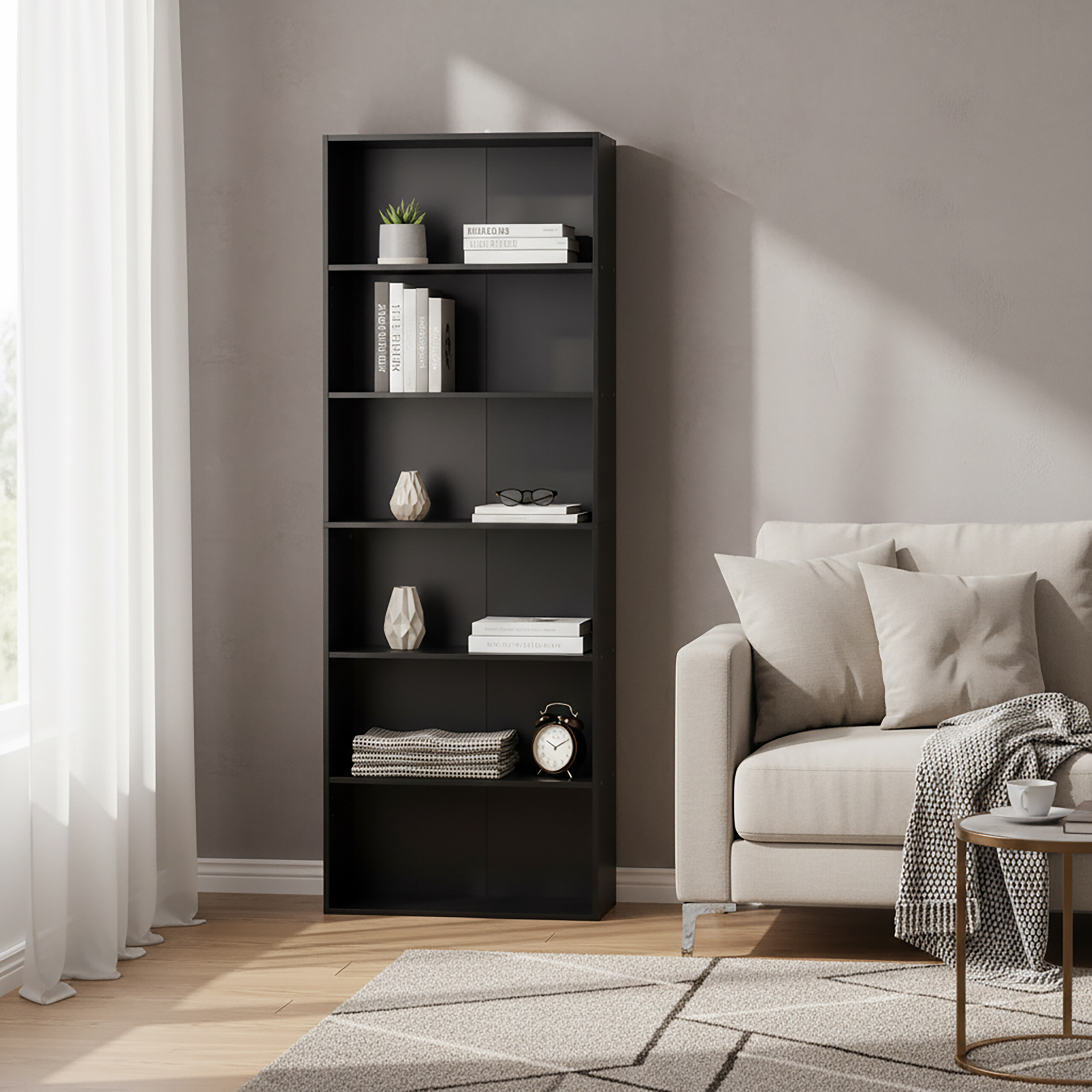 Ein schwarzes Bücherregal neben einem hellen Sofa in einem Raum mit Holzboden und Tageslicht.