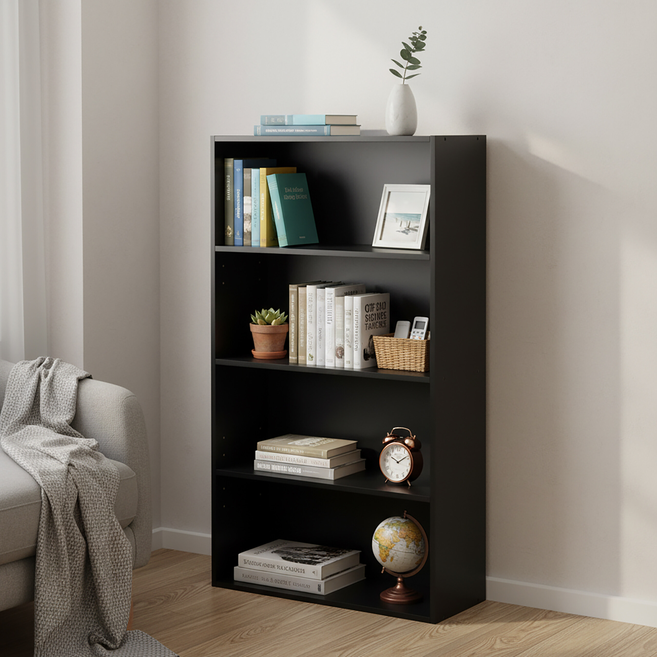 Ein schwarzes Bücherregal mit vier Regalböden ist mit Büchern, Pflanzen, einem Bilderrahmen und Dekoration gefüllt.