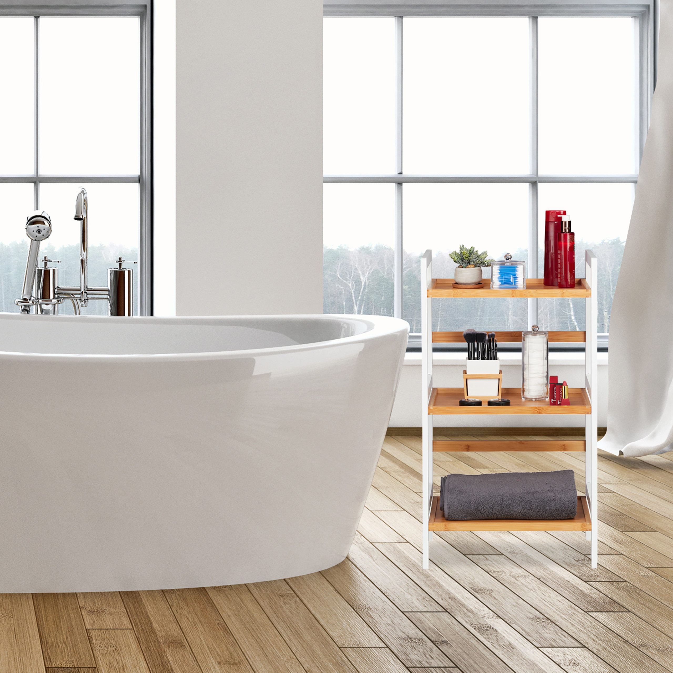 Moderne weiße Badewanne neben einem Bambusregal mit Pflegeprodukten vor großen Fenstern.