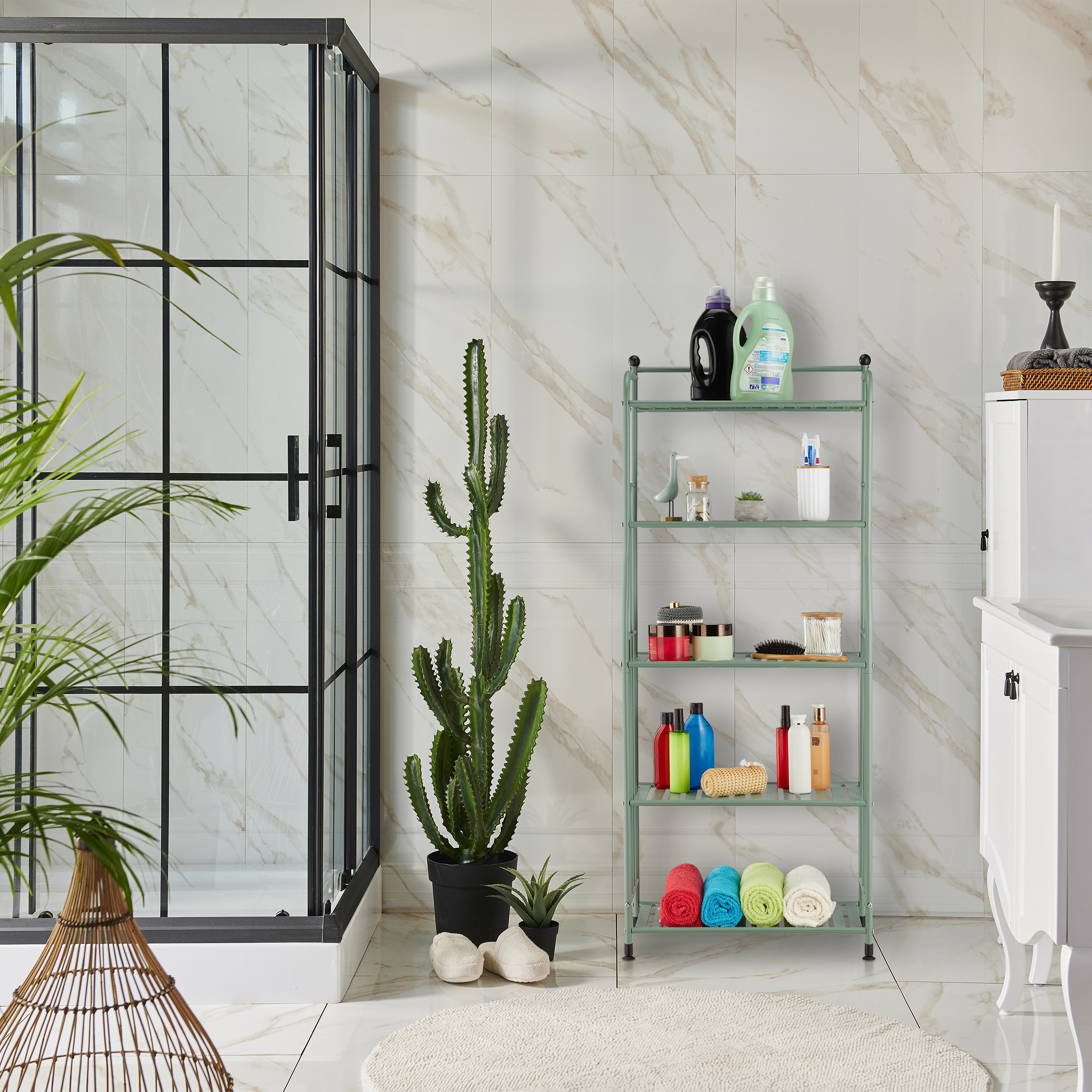Moderne Badezimmereinrichtung mit Dusche, Kakteen, grünem Regal mit Kosmetik und farbigen Handtüchern.
