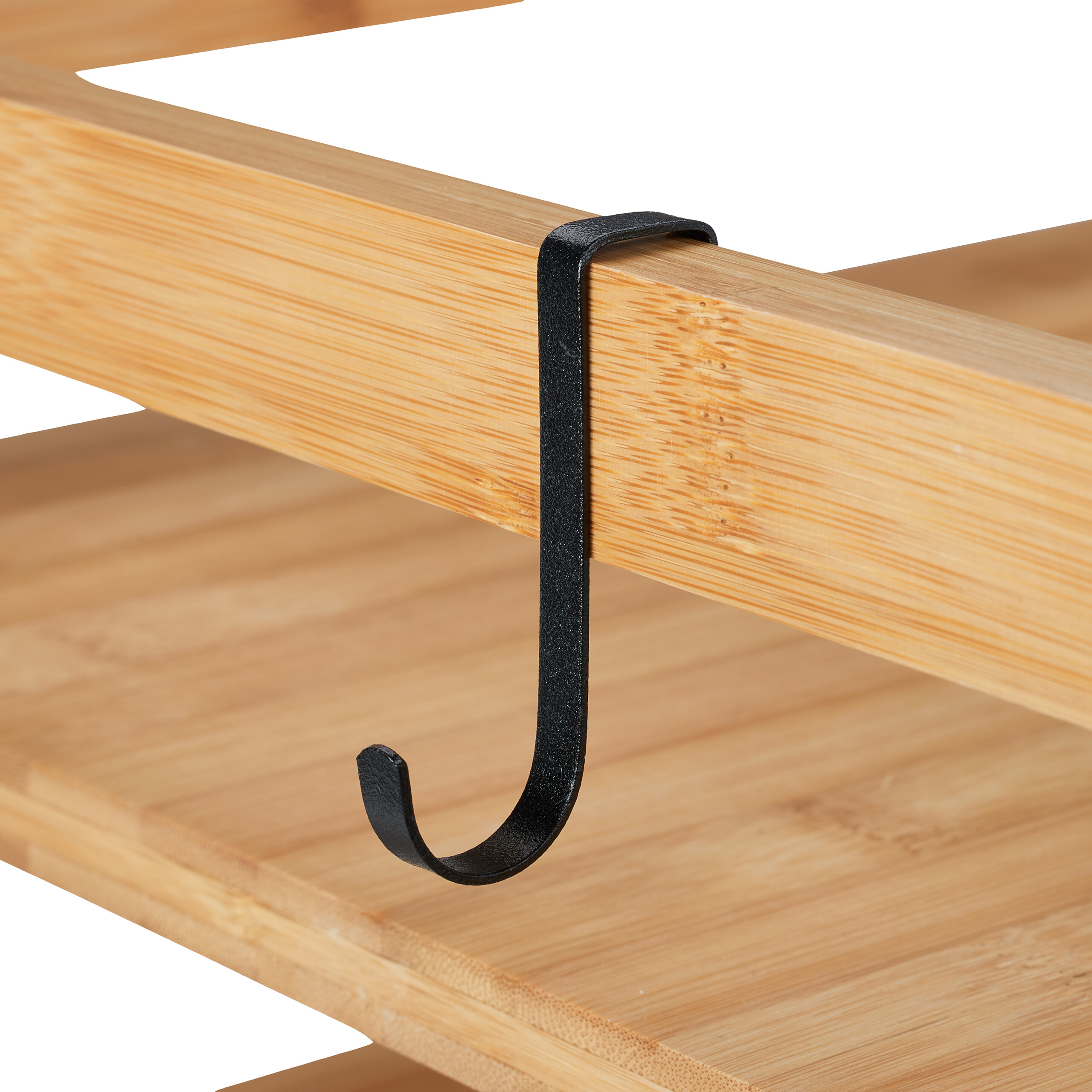 Ein schwarzer Metall-S-Haken hängt über der Holzstange eines Bambusregals.