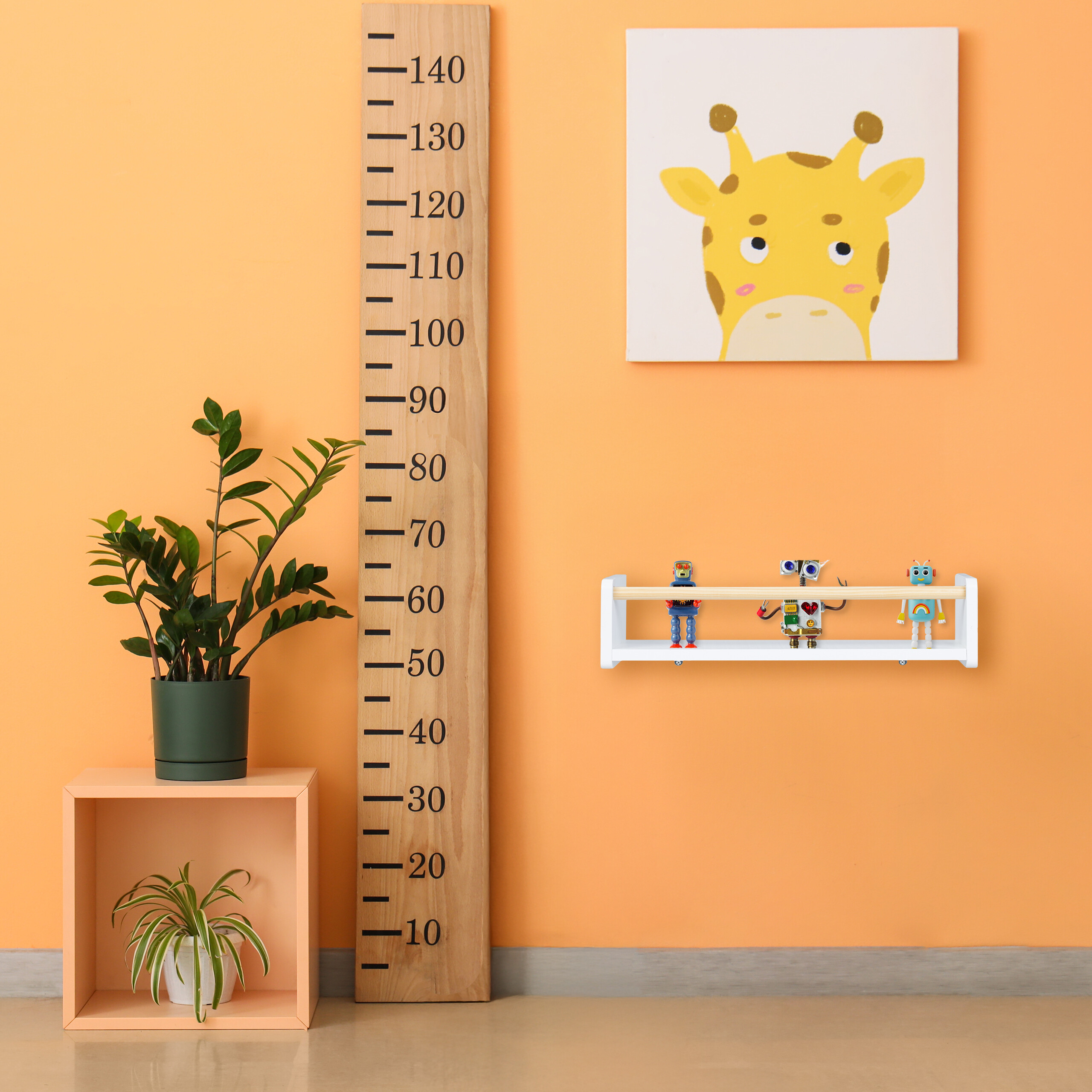 Eine orange Wand mit Holzmesslatte, Giraffenbild, kleinem Regal mit Roboterfiguren und Zimmerpflanzen.