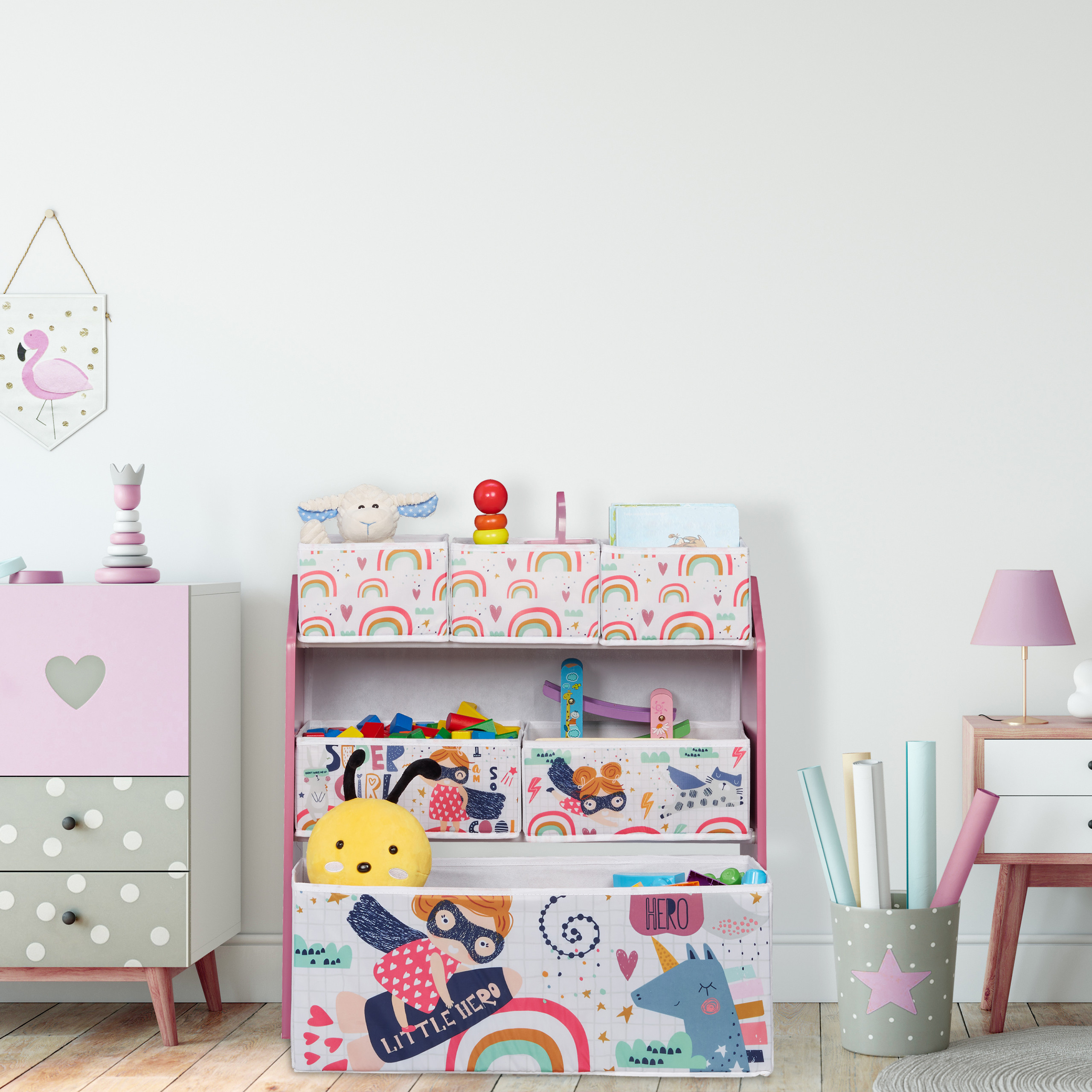 Ein Kinderzimmer mit Pastell-Aufbewahrungsboxen, einem rosa Schrank mit Herz und aufgerollten Papieren in einem Sternenhalter.
