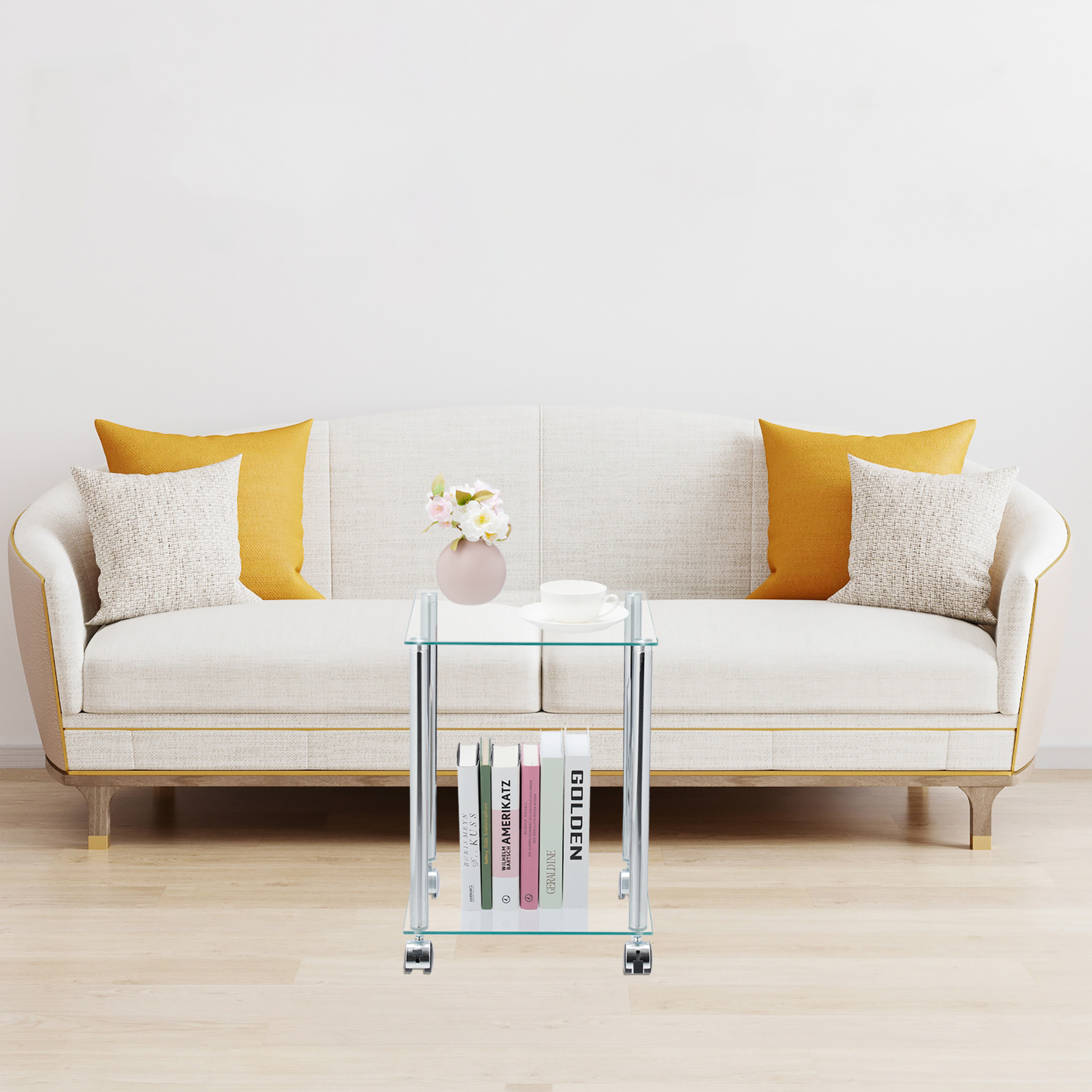 Ein weißes Sofa mit gelben Kissen und ein Glastisch mit Blumen und Büchern stehen in einem hellen Zimmer.
