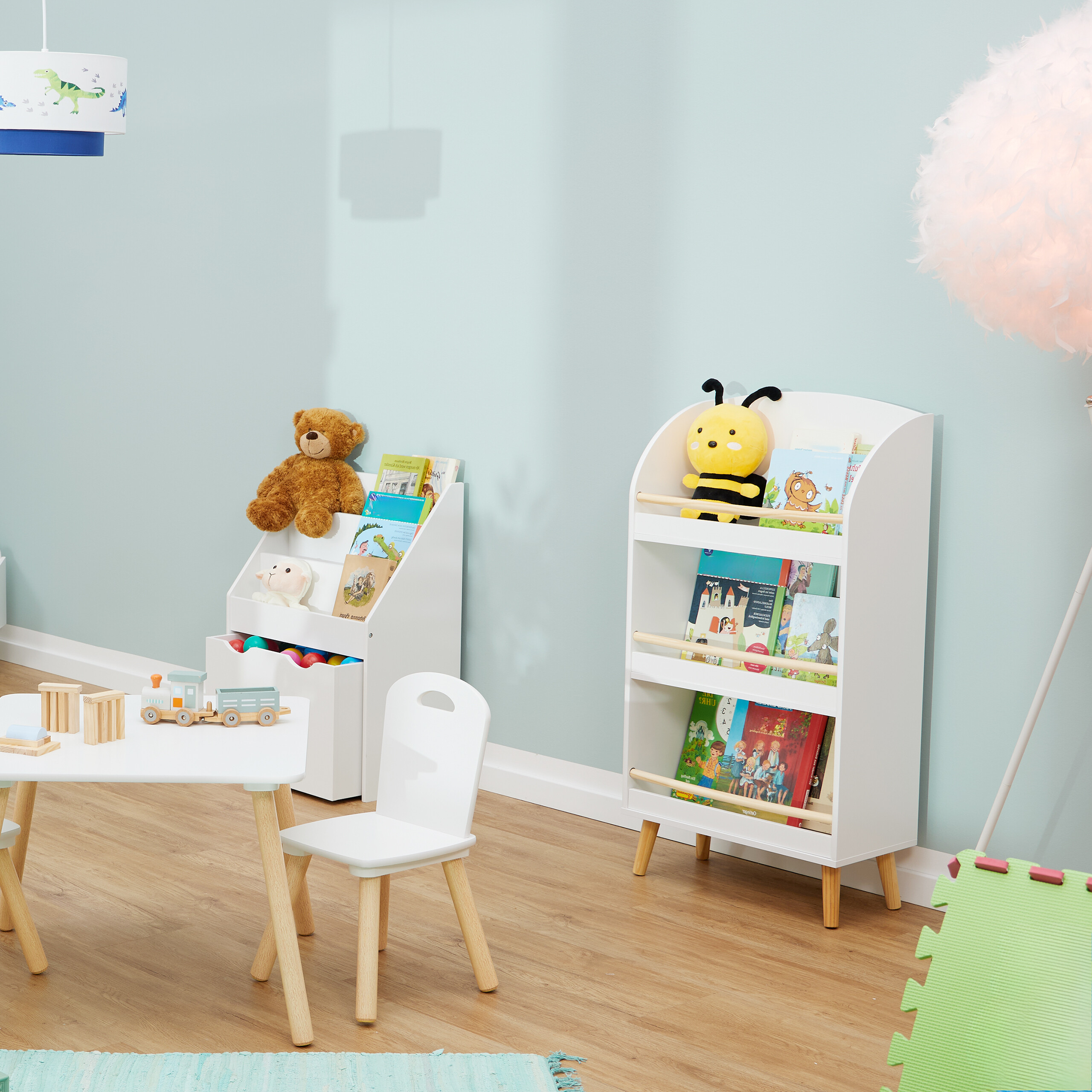 Ein kinderzimmer mit weißen regalen, büchern, plüschtieren, tisch, stuhl, dinosaurierlampe und holzboden.