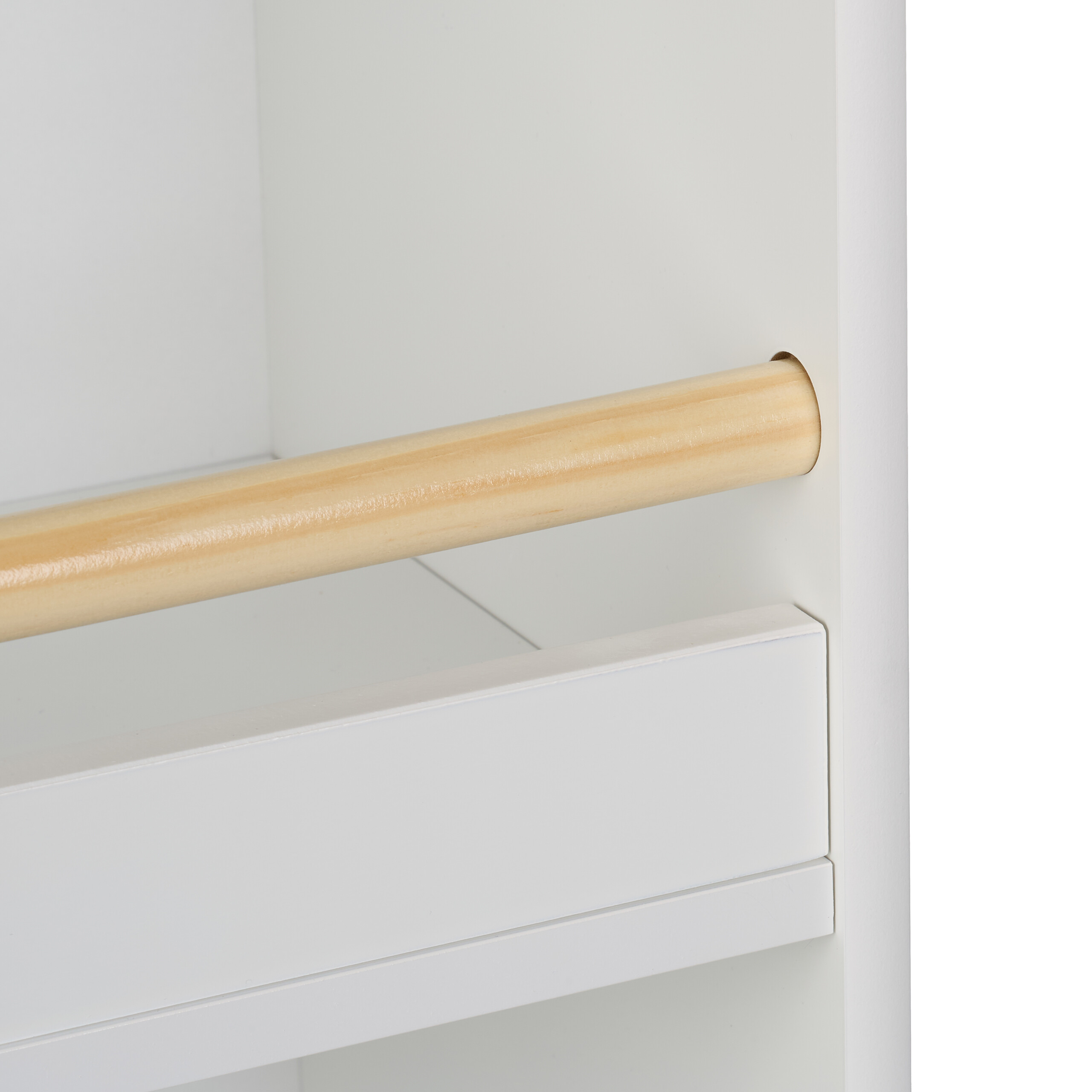 Eine hölzerne Kleiderstange in einem weißen Schrank mit Schublade.