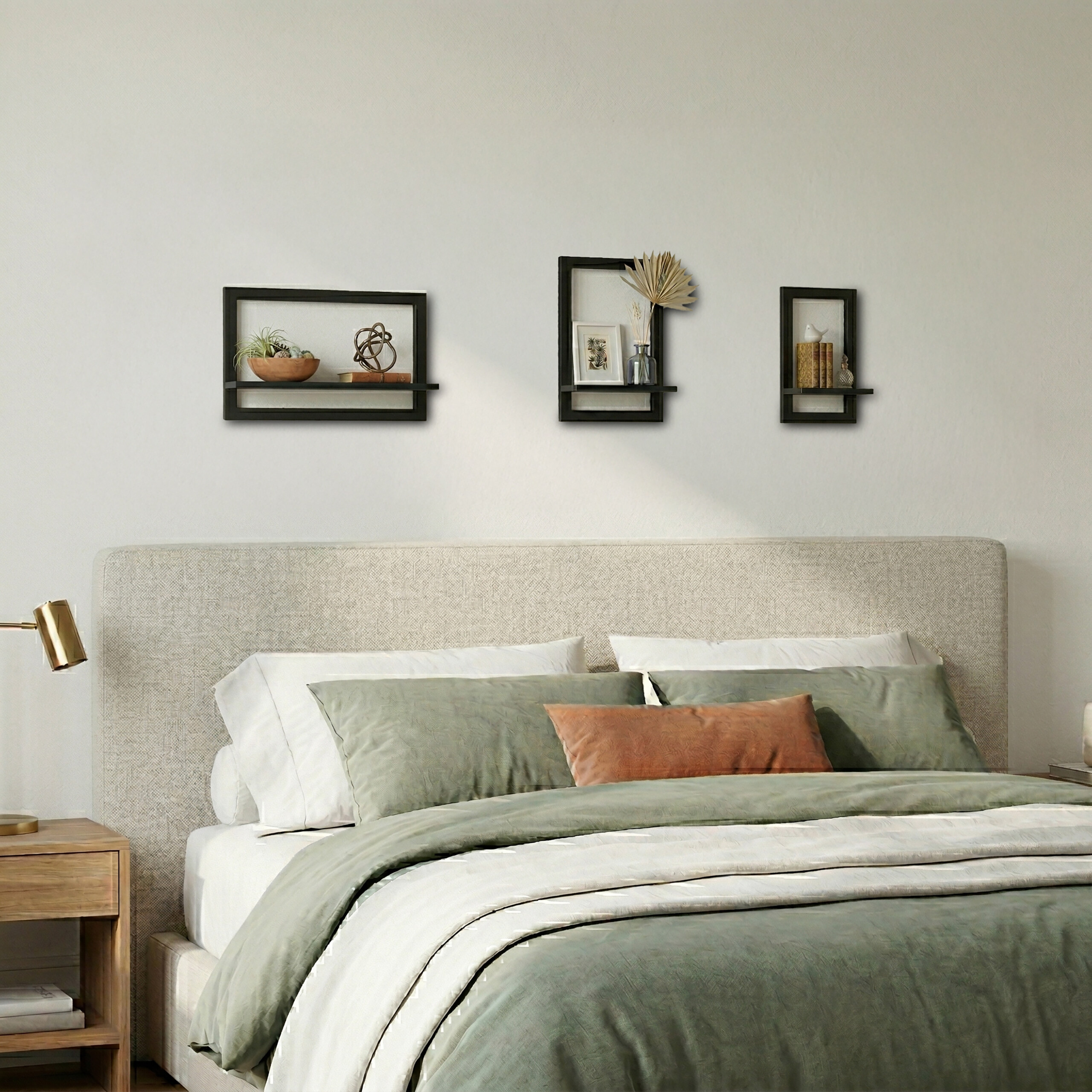 Ein gemütliches Bett mit grüne Kissen und drei schwebenden Regalen an der Wand.