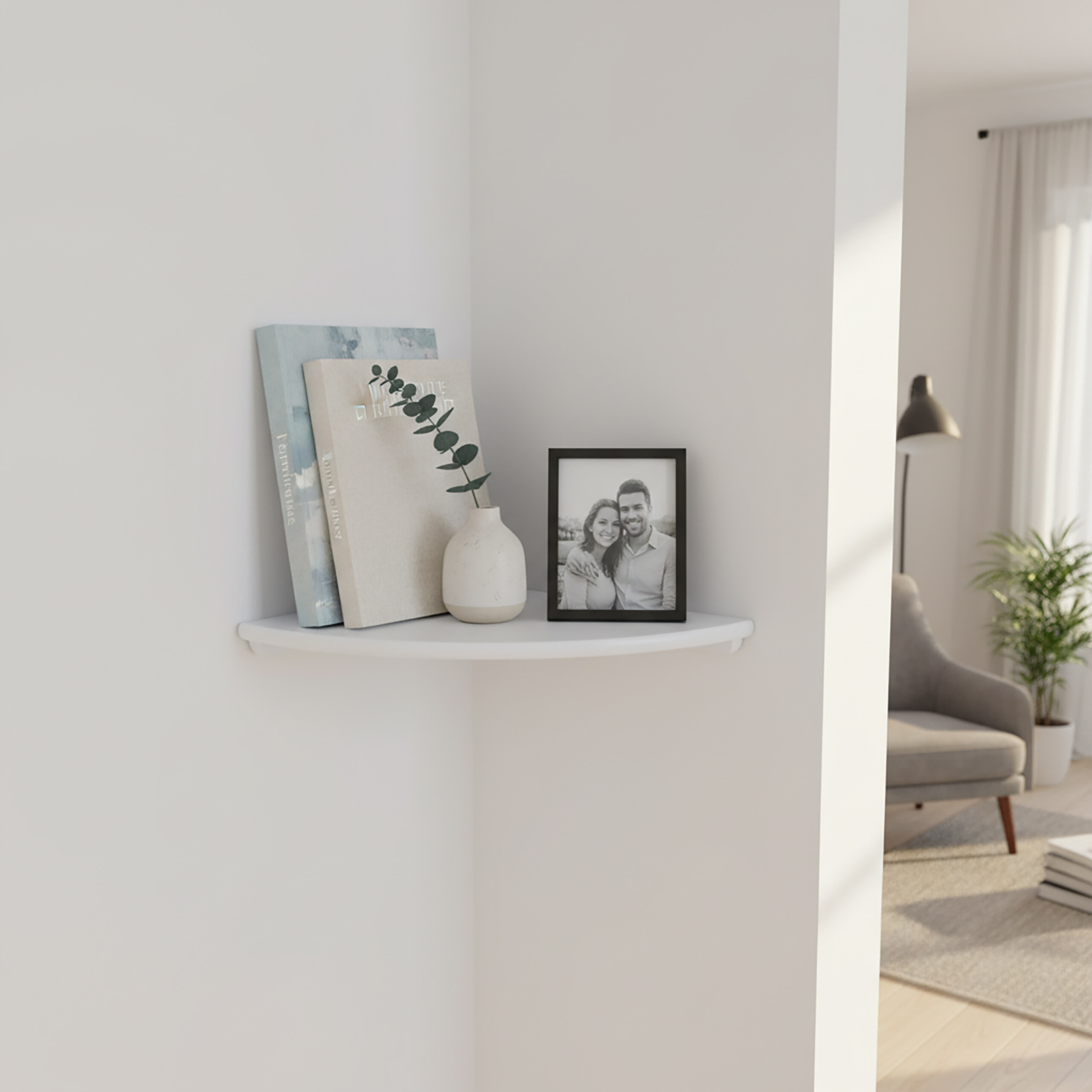 Ein weißes Eckregal mit zwei Büchern, einer Vase mit Zweig und einem gerahmten Schwarz-Weiß-Paarfoto in einem Raum.