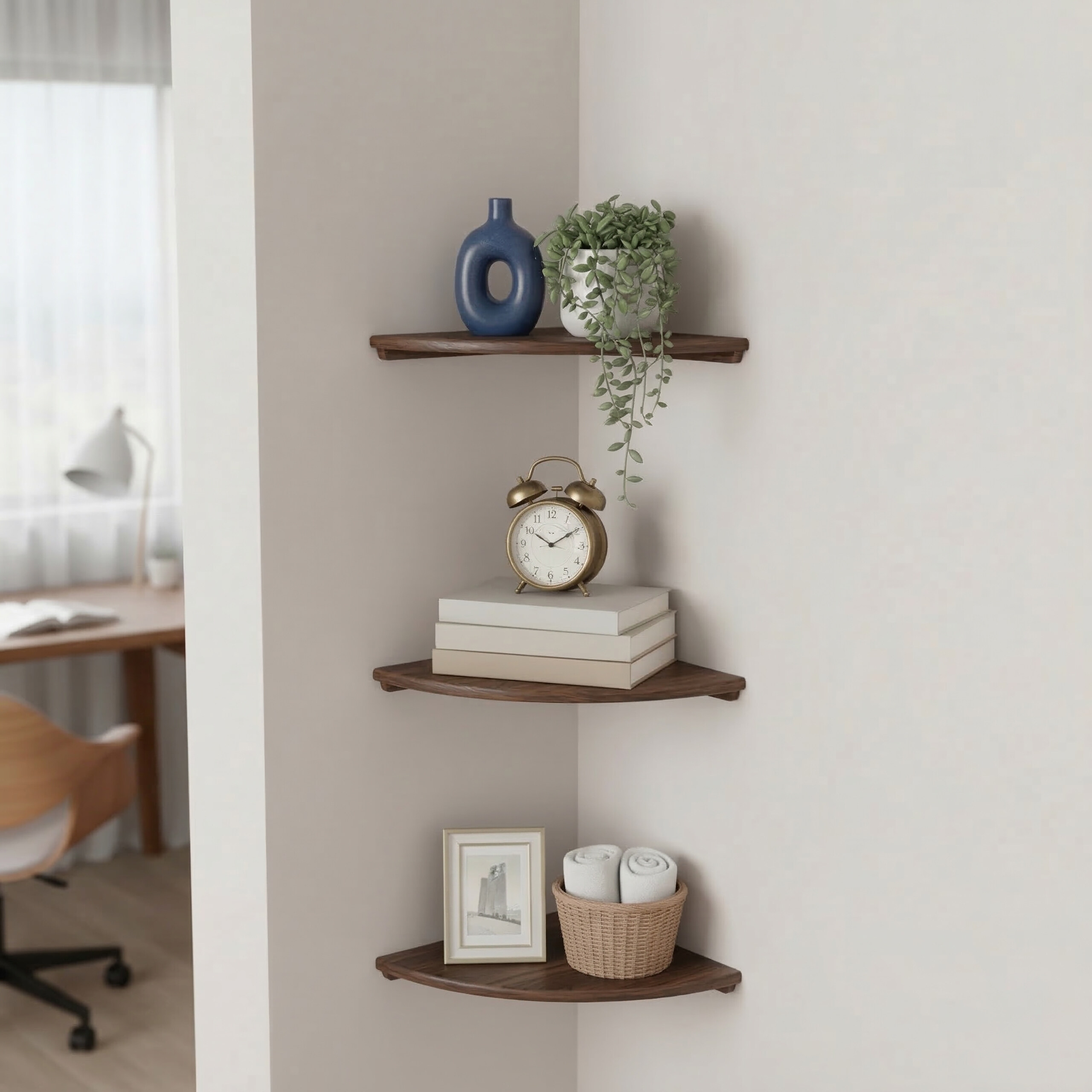 Drei hölzerne Eckregale an einer weißen Wand mit Dekoration wie Vase, Pflanzen, Uhr, Büchern und Handtüchern.