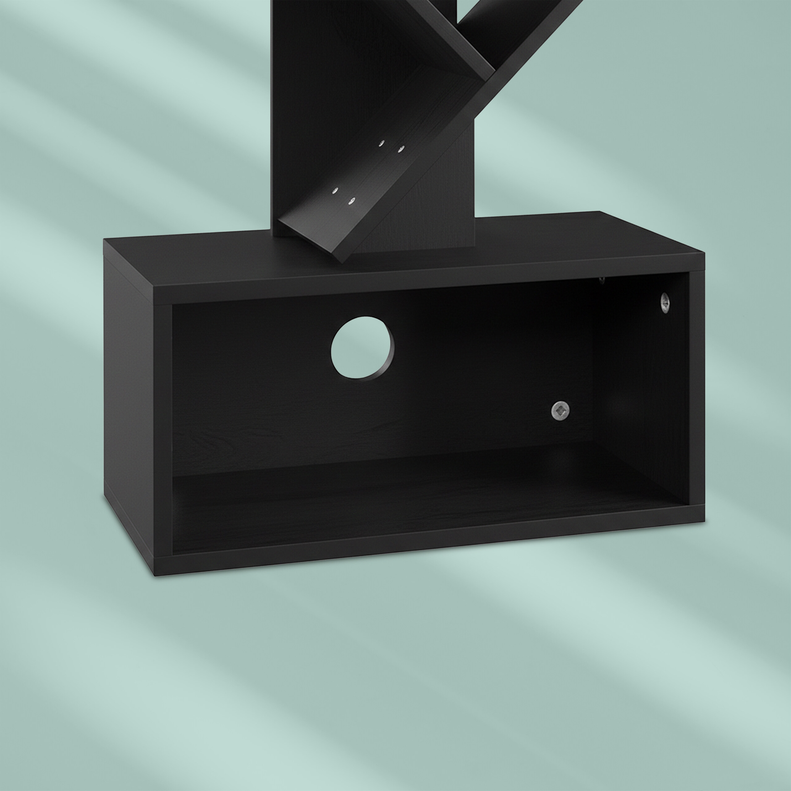 Ein schwarzes Wandregal mit offener Box und Kabeldurchlass vor einer hellgrünen Wand.