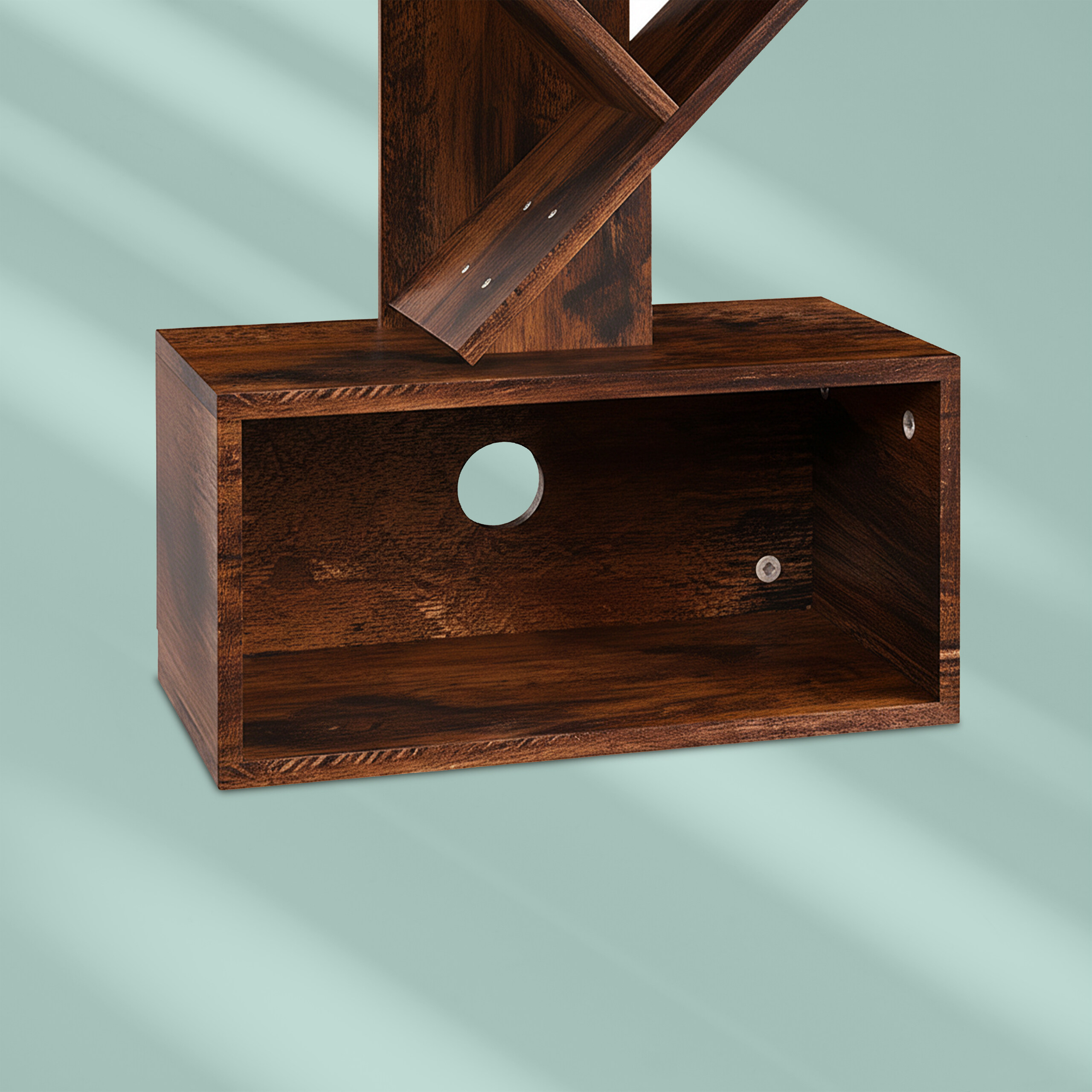 Ein dunkles Holzregal mit einem rechteckigen Fach und kreuzförmigen Elementen auf türkisfarbenem Hintergrund.