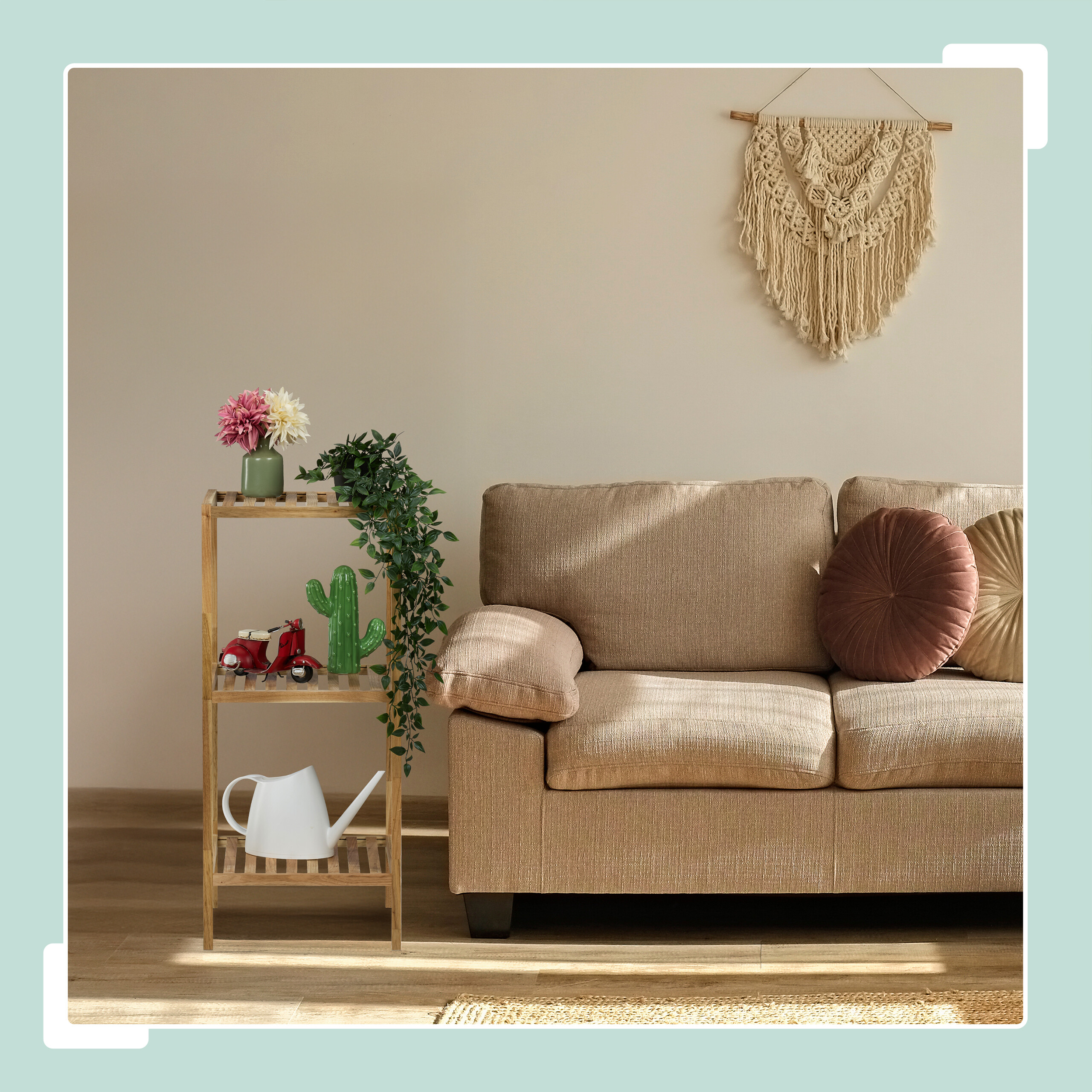 Gemütliches Wohnzimmer mit beigem Sofa, Holzregal mit Pflanzen und Makramee-Wandbehang.