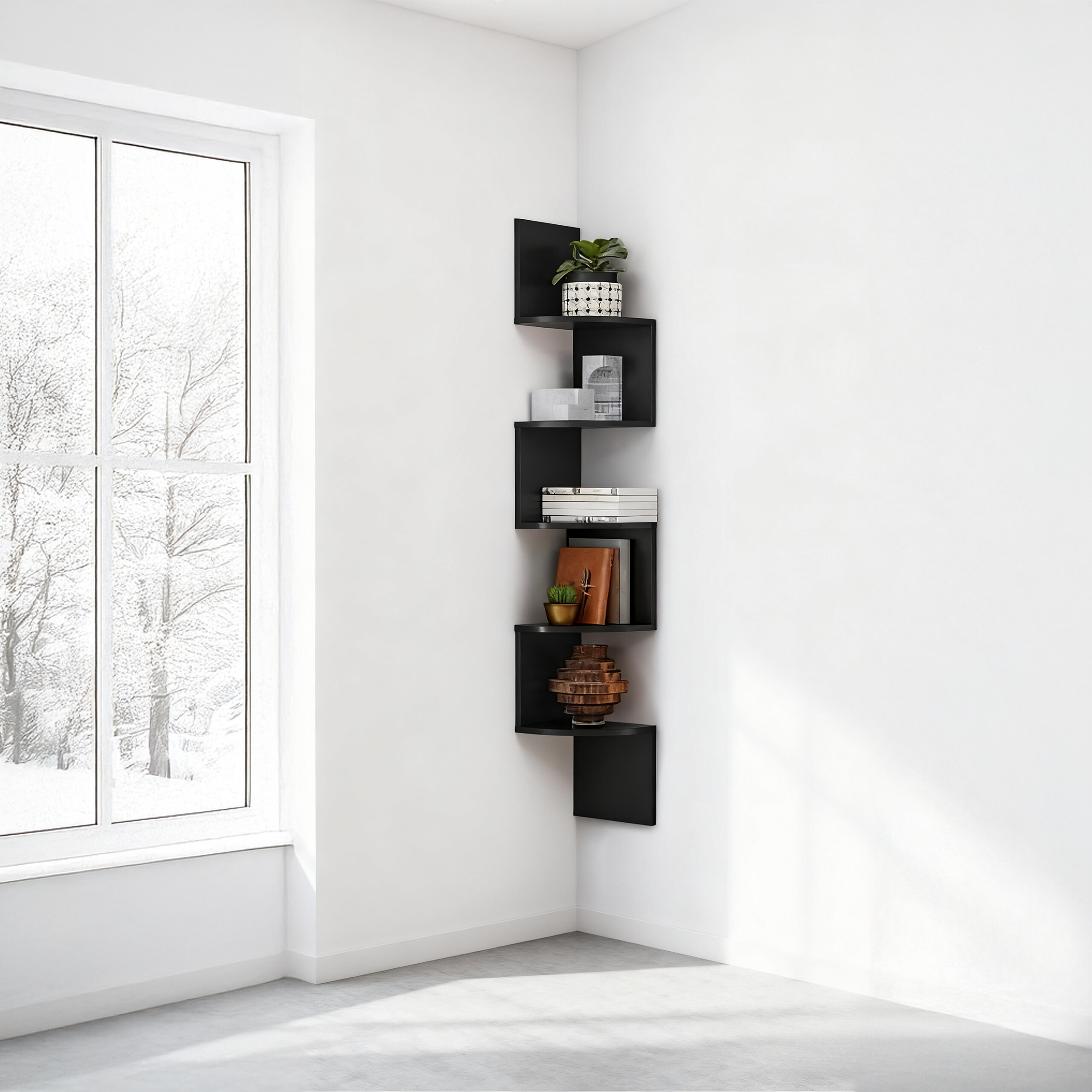 Ein schwarzes Eckregal mit Büchern und Dekoration an einer weißen Wand neben einem Fenster mit Schneeblick.