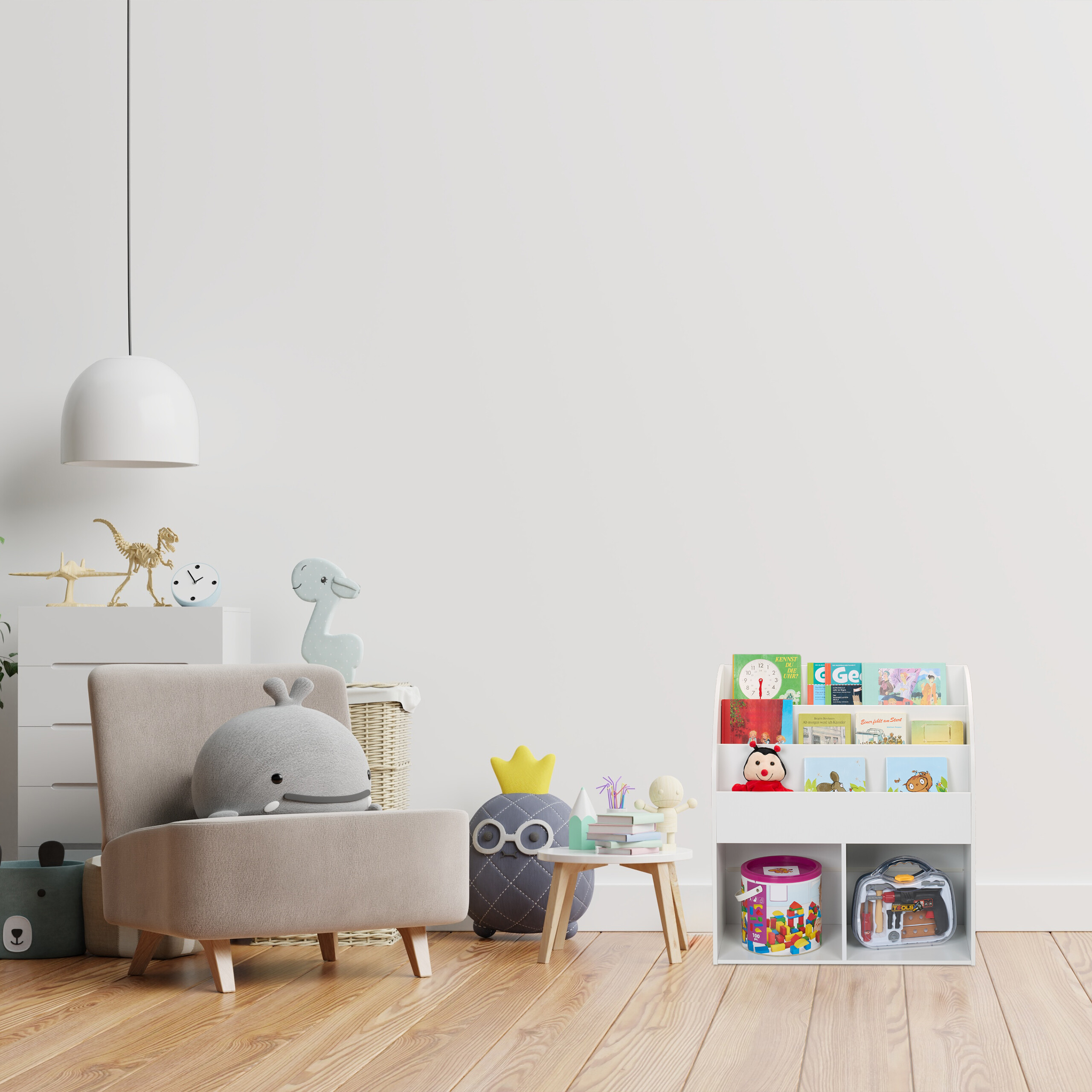Gemütliches Kinderzimmer mit Sessel, Wal-Kissen, Bücherregal und Spielzeug vor weißer Wand und Holzboden.