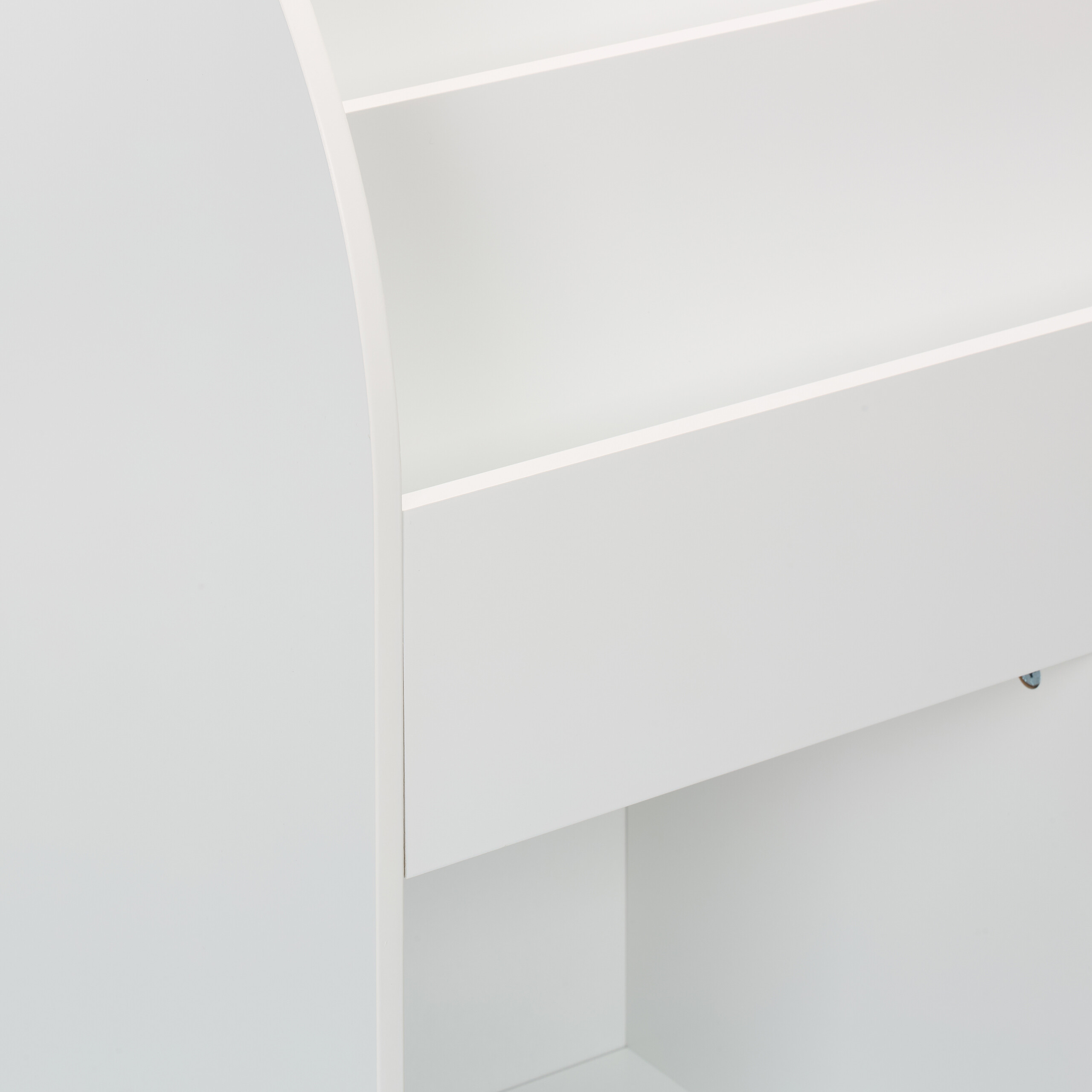 Ein weißes Bücherregal aus Holz mit geschwungenen Seiten und mehreren Regalböden zeigt feine Details.