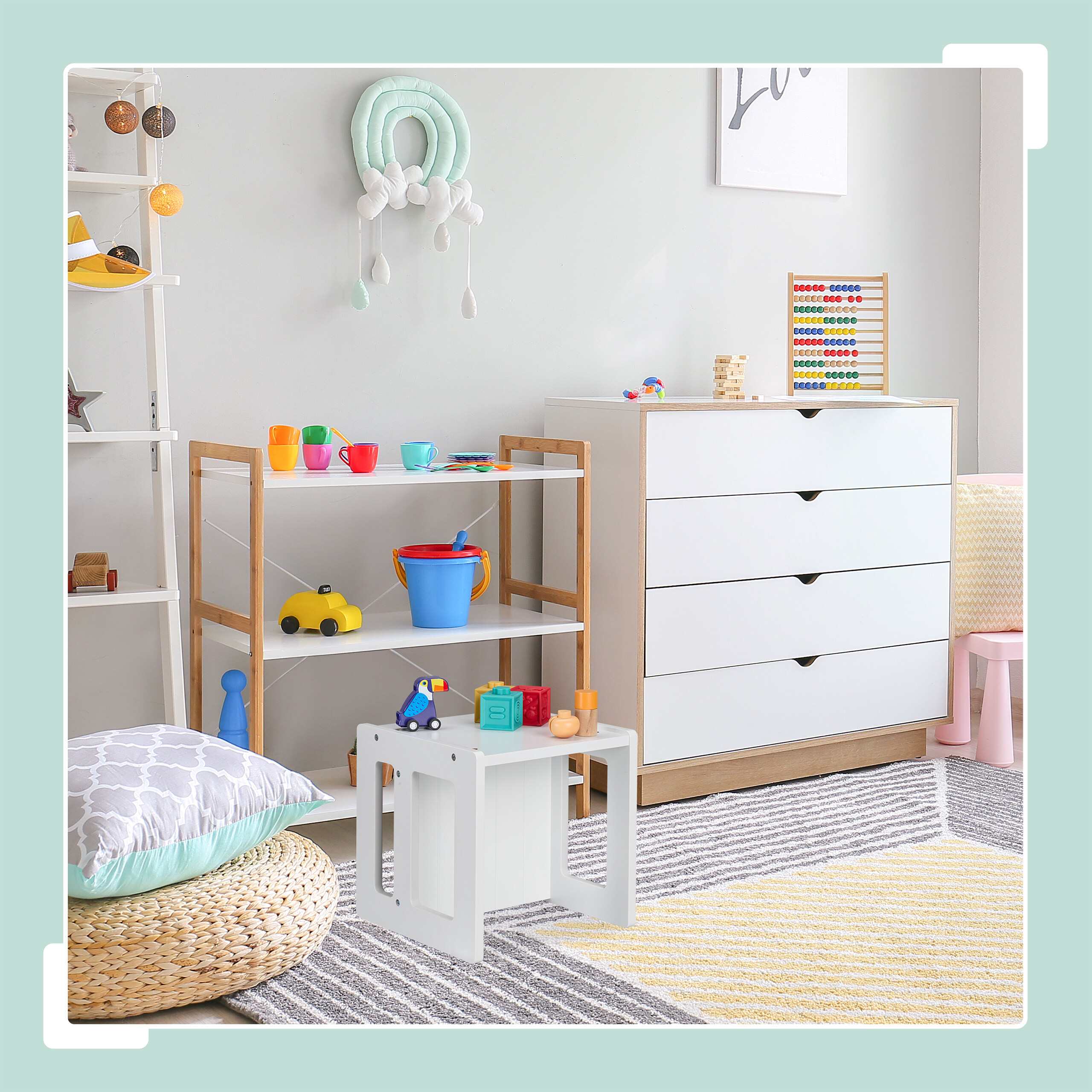 Ein helles Kinderzimmer mit weißer Kommode, Regalen voller Spielzeug, Teppich und Kissen auf dem Boden.