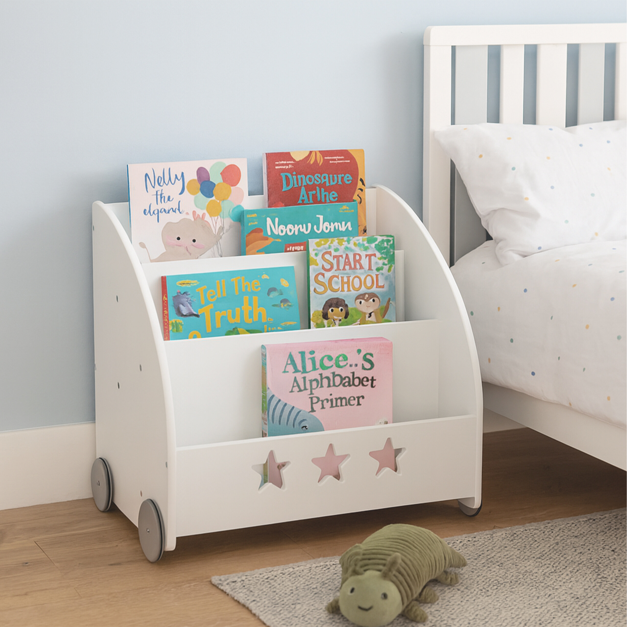 Ein weißes, fahrbares Bücherregal für Kinder gefüllt mit bunten Büchern, daneben ein Bett und ein Stofftier auf dem Teppich.