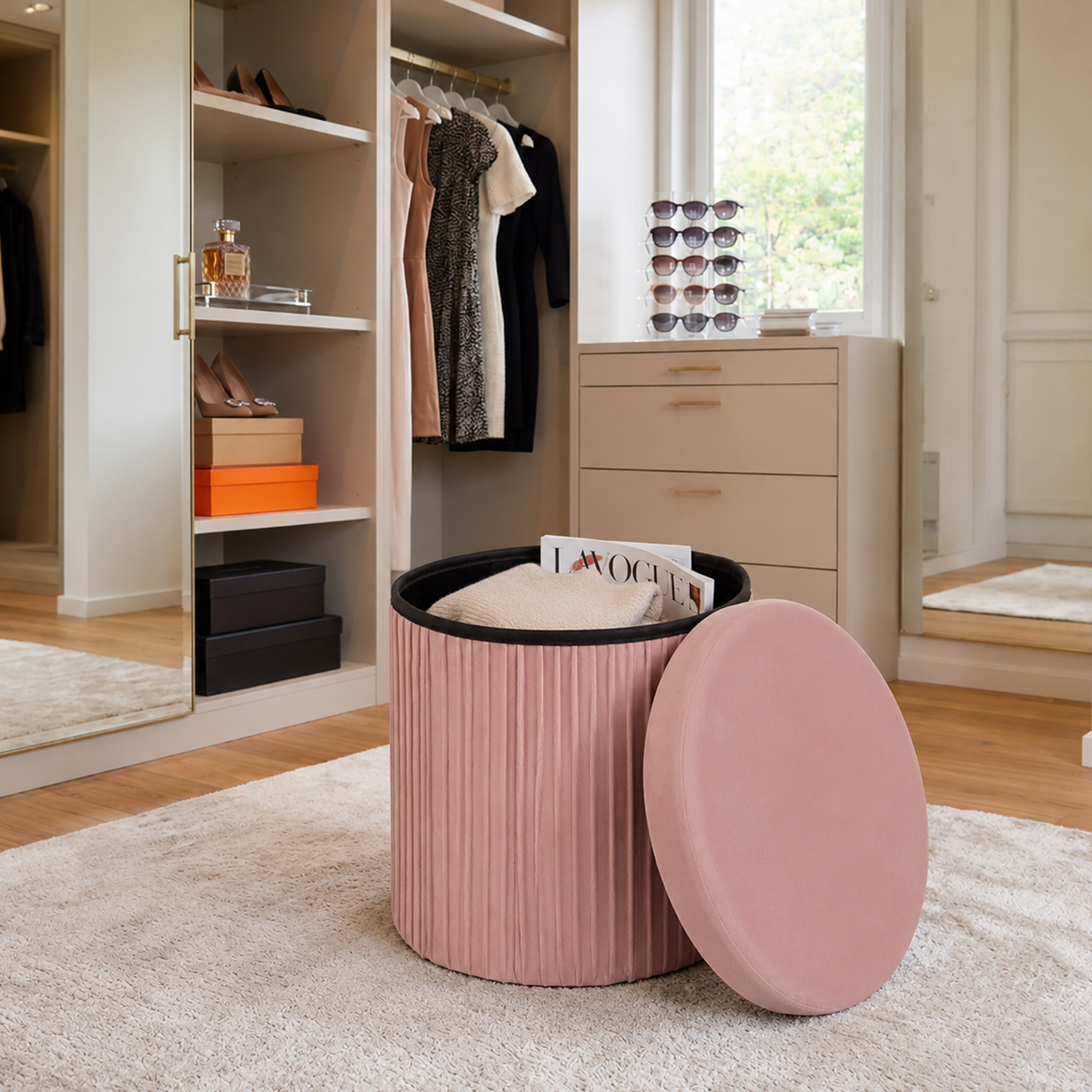 Rosa Plüschhocker mit offenem Deckel und Magazin im hellen Ankleidezimmer mit Kleiderschrank.