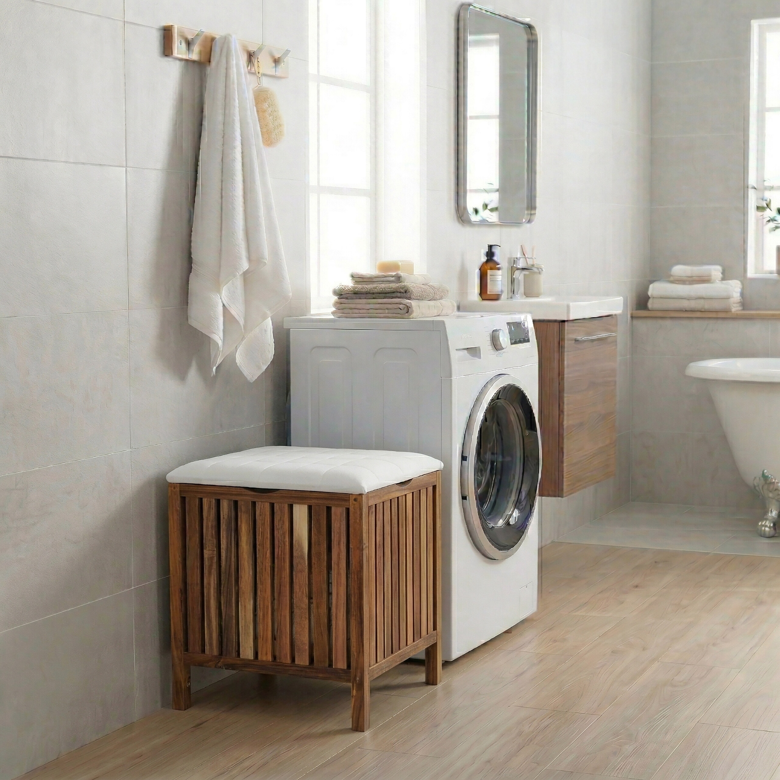 Ein helles Badezimmer mit Waschmaschine, Holzstuhl, Handtüchern, Waschbecken und Badewanne auf Holzboden.