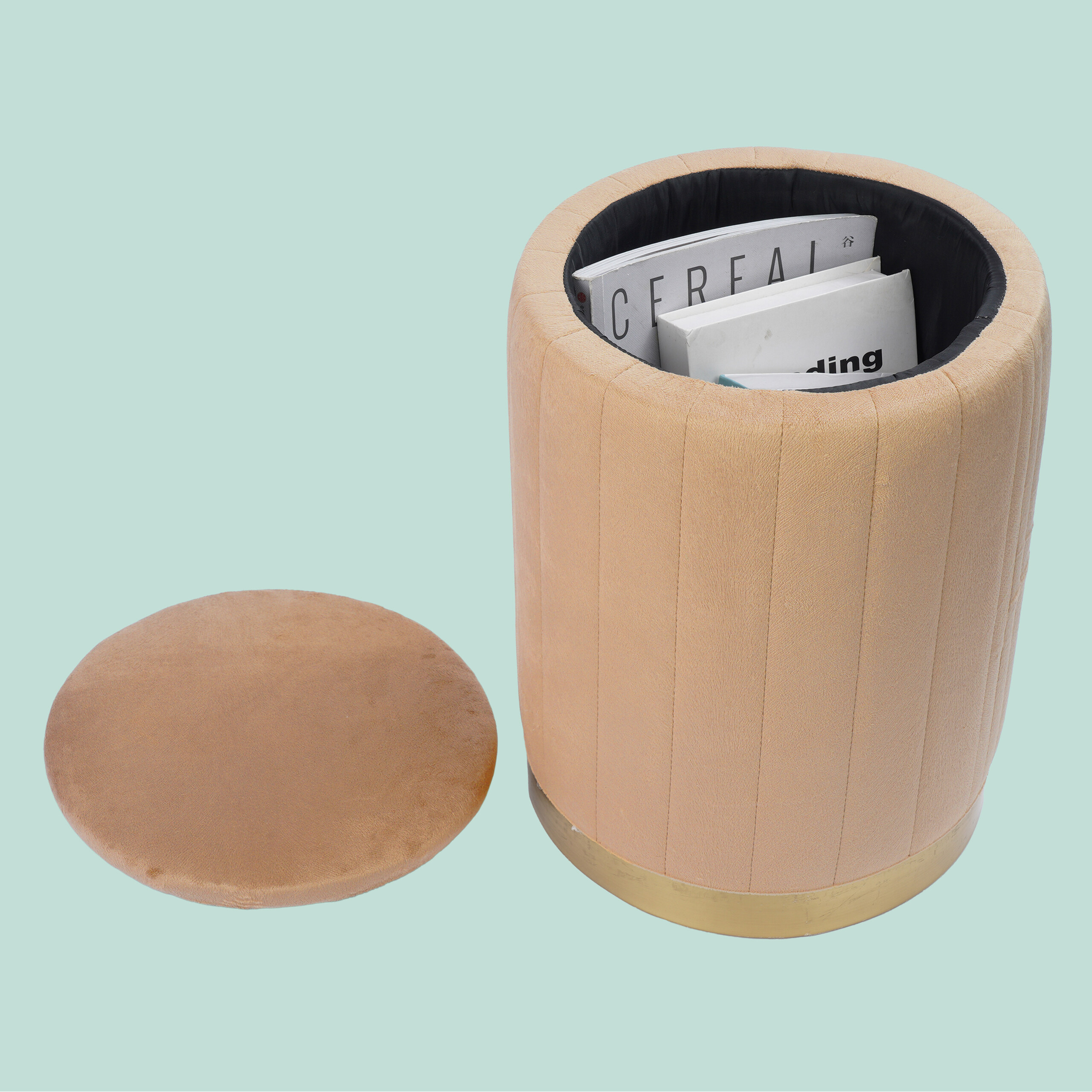 Ein beiger, zylindrischer Hocker mit Stauraum voller Zeitschriften und dem dazugehörigen runden Deckel daneben.