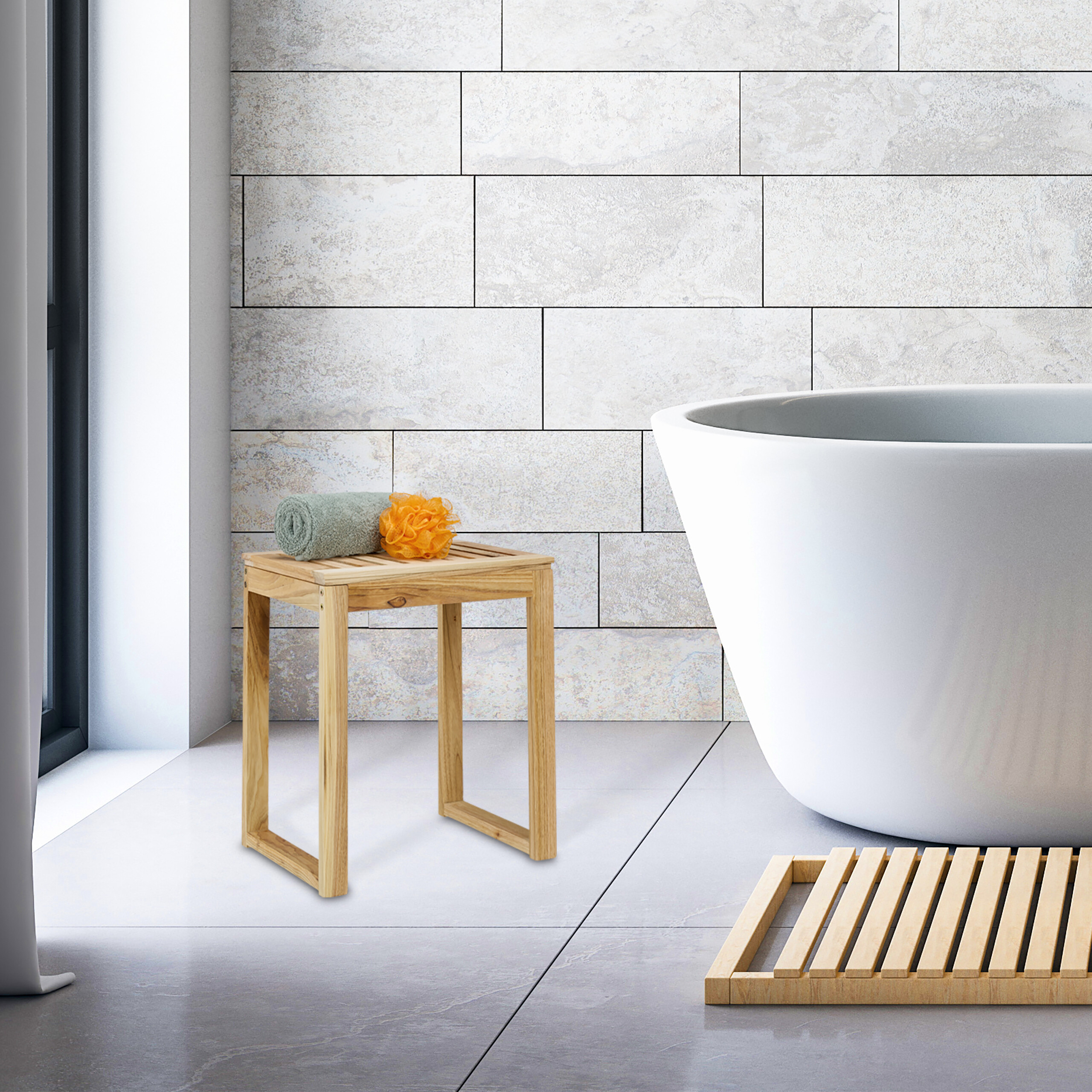 Eine moderne weiße Badewanne neben einem Holzschemel mit Handtuch und Schwamm vor hellgrauen Fliesenwänden.