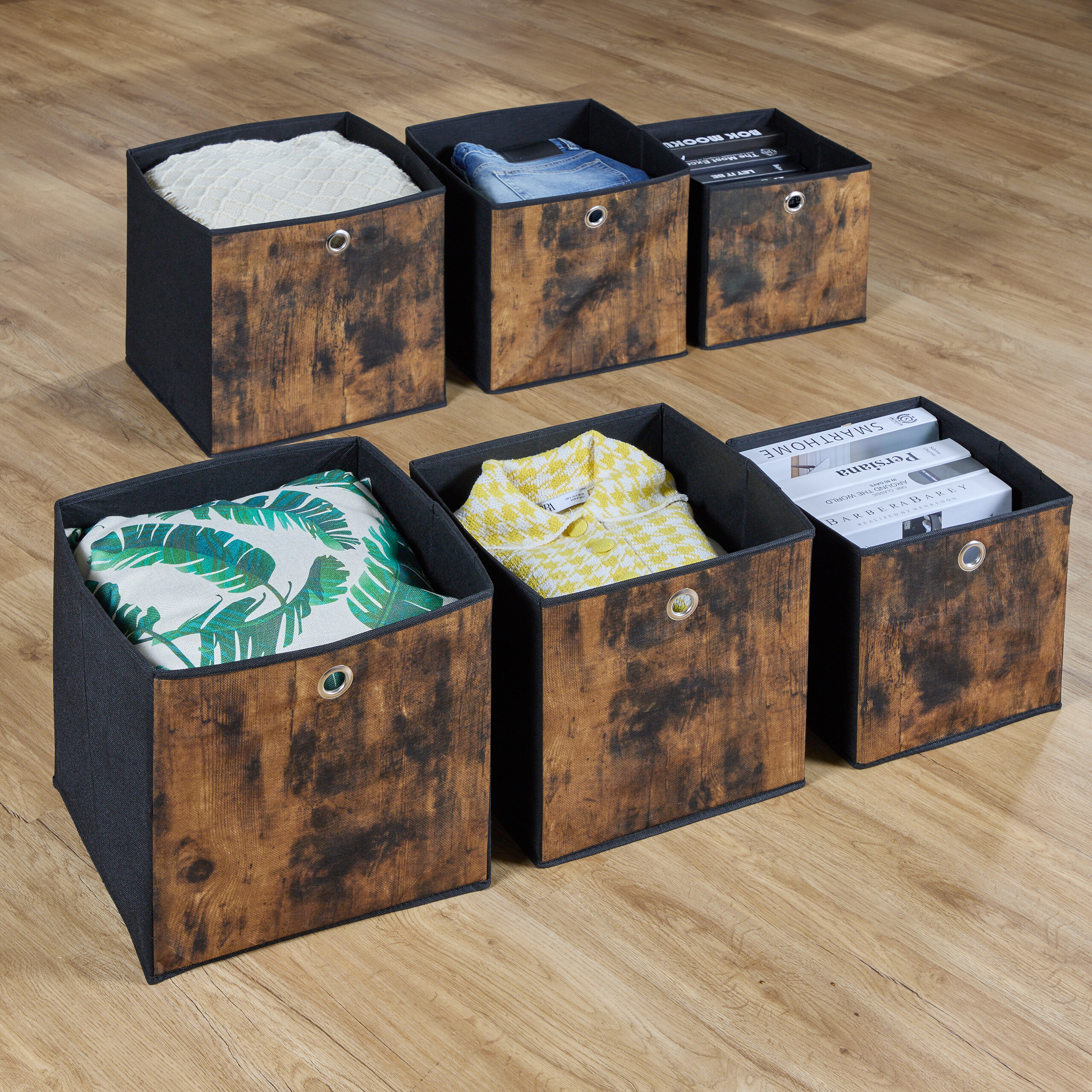 Sechs Aufbewahrungsboxen mit braunem Holzmuster und Stoffrändern sind ordentlich auf einem Holzboden platziert.