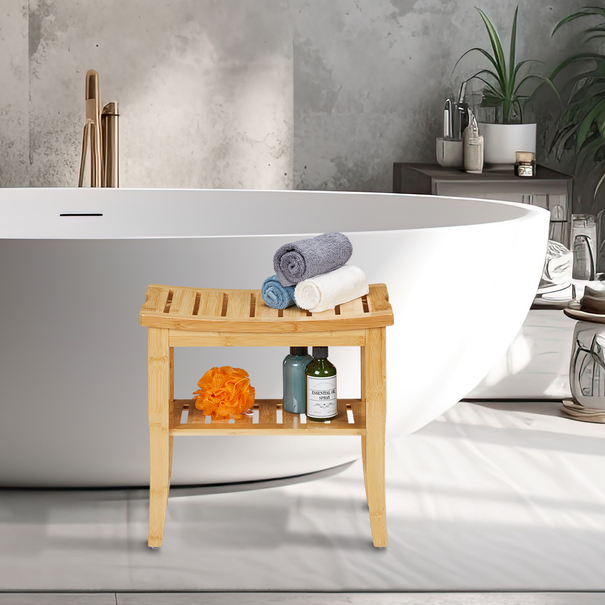 Bambus-Badematte mit gerollten Handtüchern, Flaschen und einem orangefarbenen Duschschwamm vor einer runden Badewanne.
