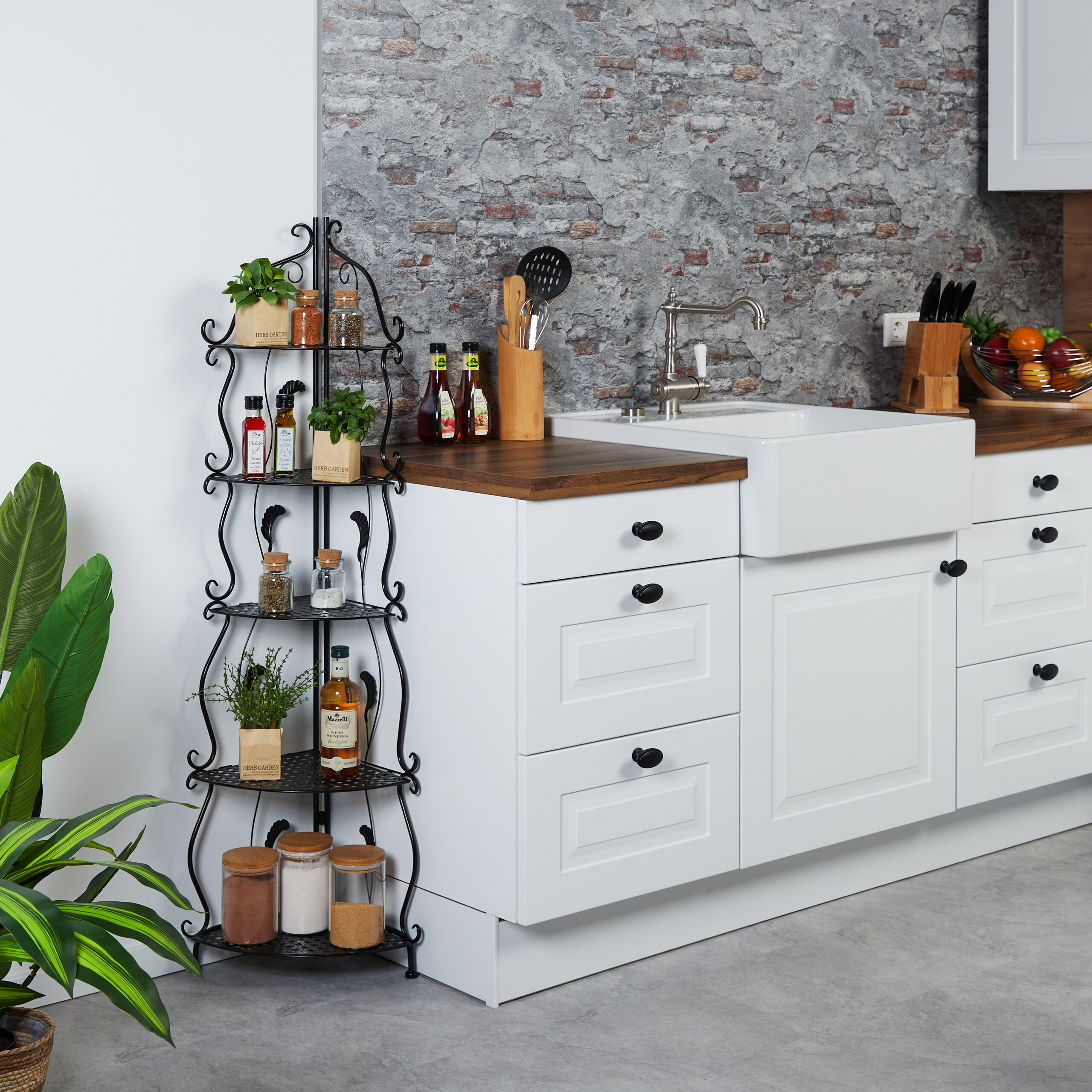 Moderne Küche mit weißen Schränken, Holzarbeitsplatte, Waschbecken und einem schwarzen Metallregal voller Gewürze.
